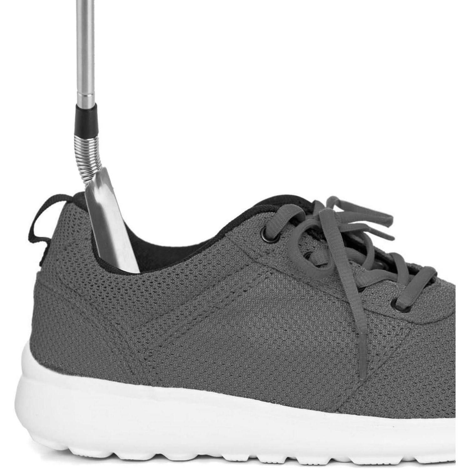 Metallacher wird in die Ferse eines grauen Sneakers mit weißer Sohle eingeführt und hilft beim Ausziehen oder Anziehen des Schuhs.