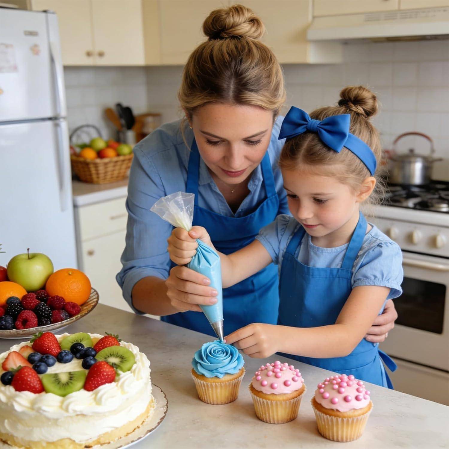 Mutter und kleine Tochter in einer Küche dekorieren Cupcakes mit blauem Frosting, mit einem Kuchen und frischem Obst in der Nähe.