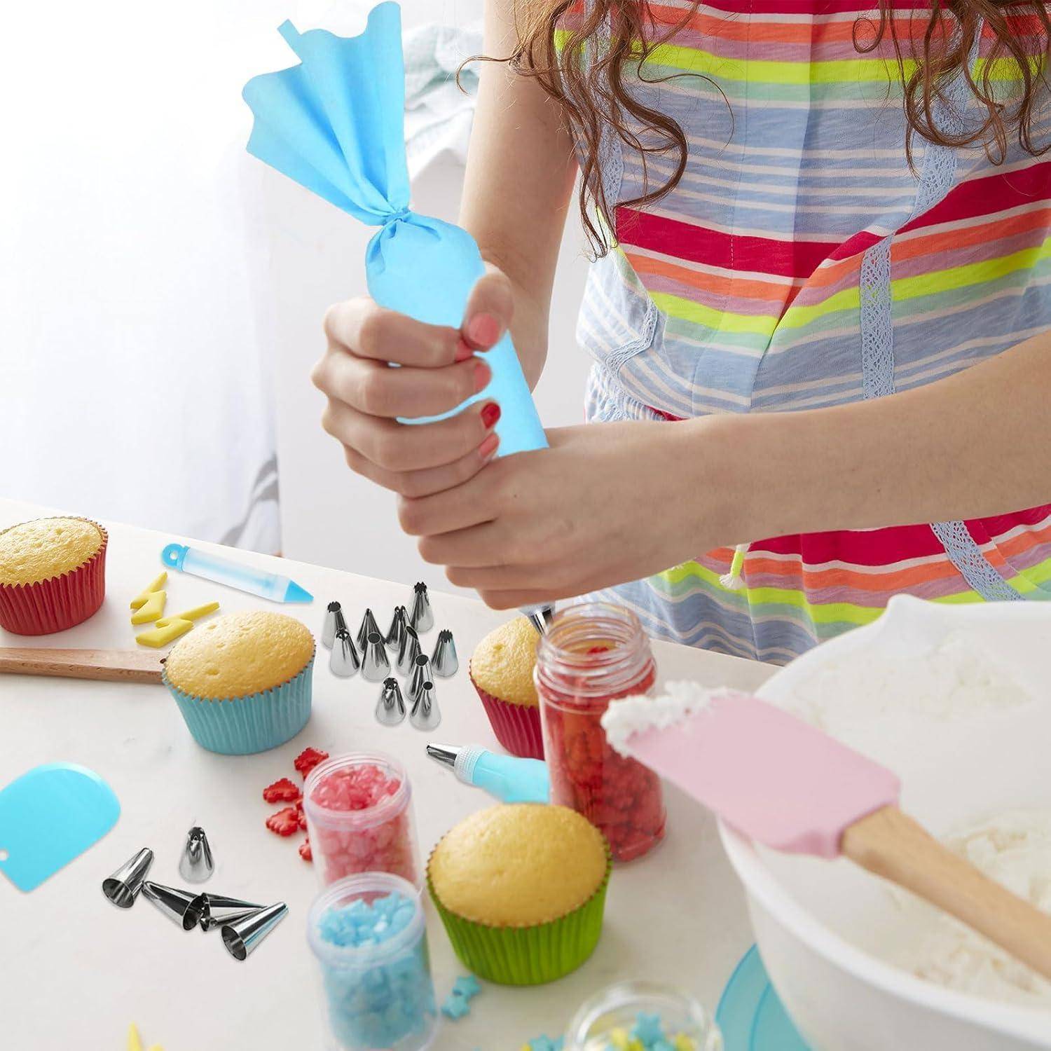 Person, die Cupcakes verziert, blaue Glasur mit einem Spritzbeutel auf einen Cupcake aufträgt, an einem Backtisch mit Cupcakes, Spritzbeuteln, Streuseln und Verzierungstüllen.