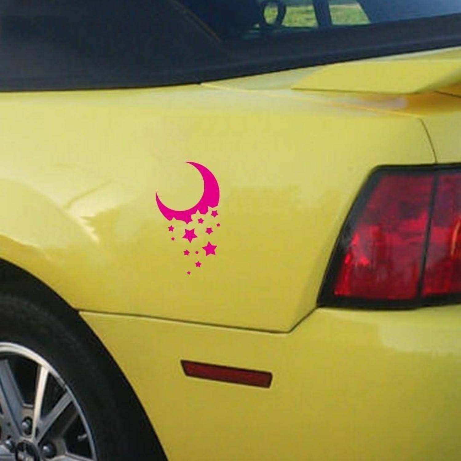 Gelbes Auto-Heckflügel mit einem rosa Halbmond und Sternen Aufkleber in der Nähe des Rücklichts.