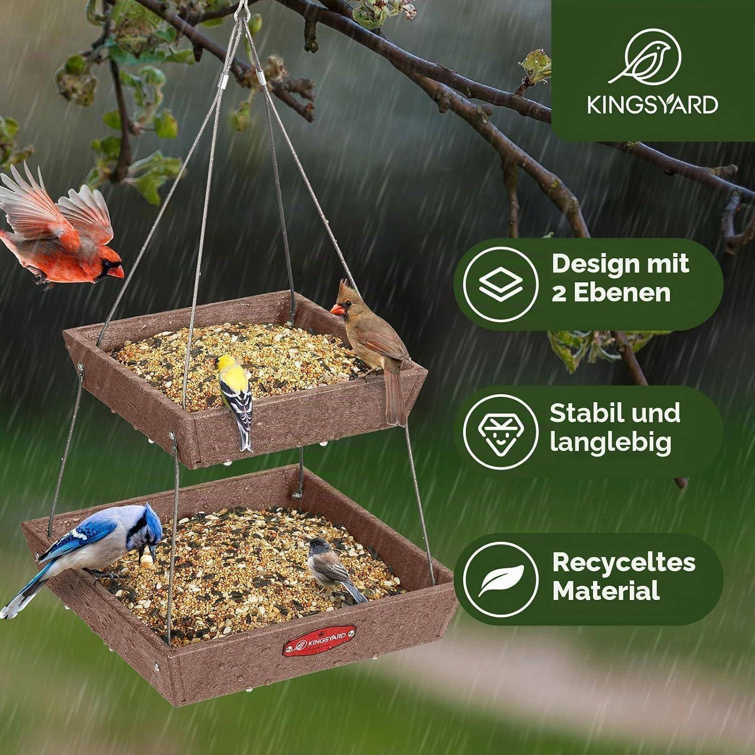 Hängender Vogelfutterplatz mit zwei Ebenen gefüllt mit Samen, mit Vögeln, die im Regen fressen; Text sagt „Design mit 2 Ebenen