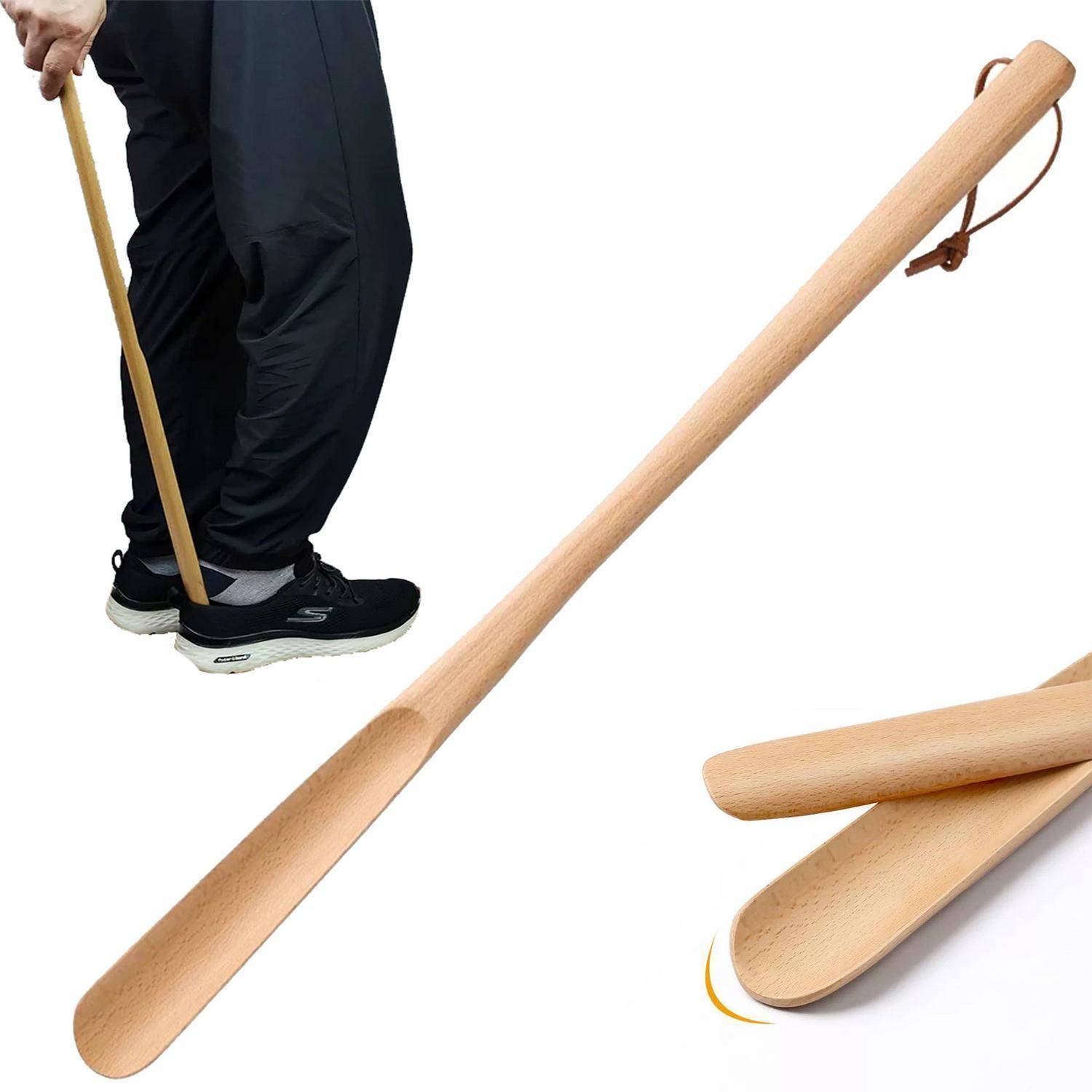 Eine Person benutzt einen langen Schuhanzieher aus Holz, um einen schwarzen Turnschuh anzuziehen; zusätzliche Schuhanzieher werden auf weißem Hintergrund gezeigt.