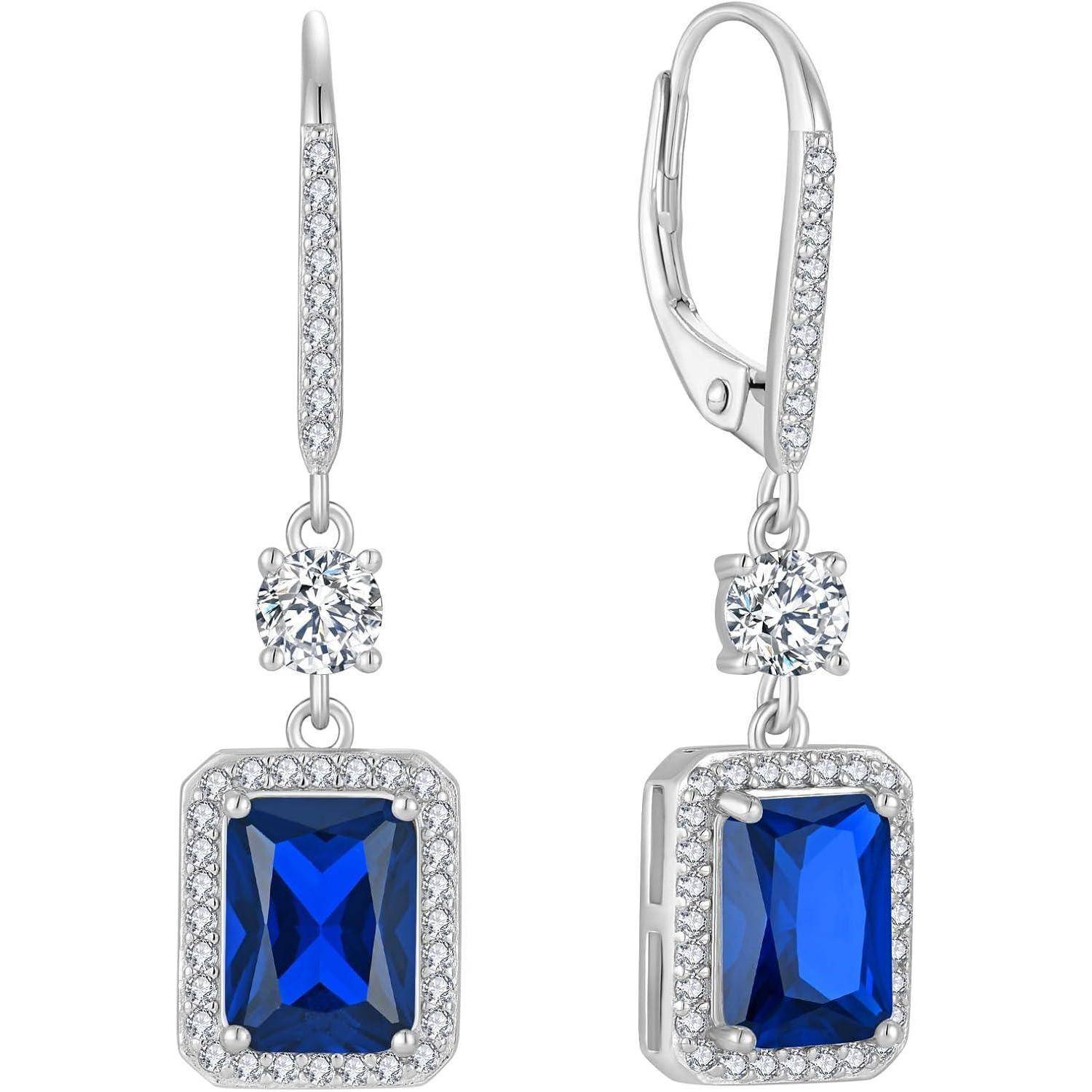 Silberne Tropfenohrringe mit blauen rechteckigen Edelsteinen, kleinen runden Diamanten und einem baumelnden runden Diamanten über jedem Stein.