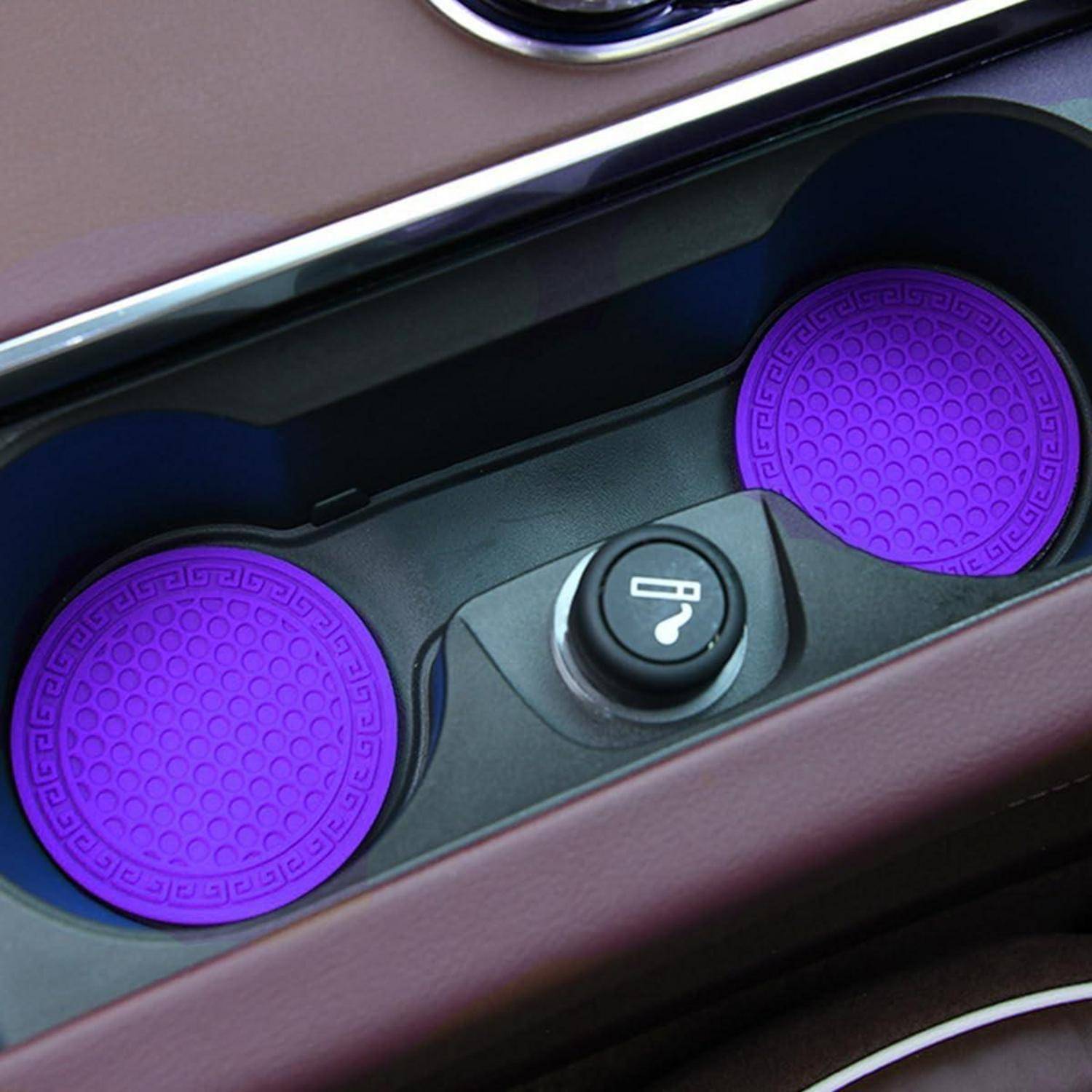 Mittelkonsole des Autoinnenraums mit zwei violetten runden Getränkehalter-Einsätzen und einer zentralen Abdeckung für eine 12-V-Steckdose.