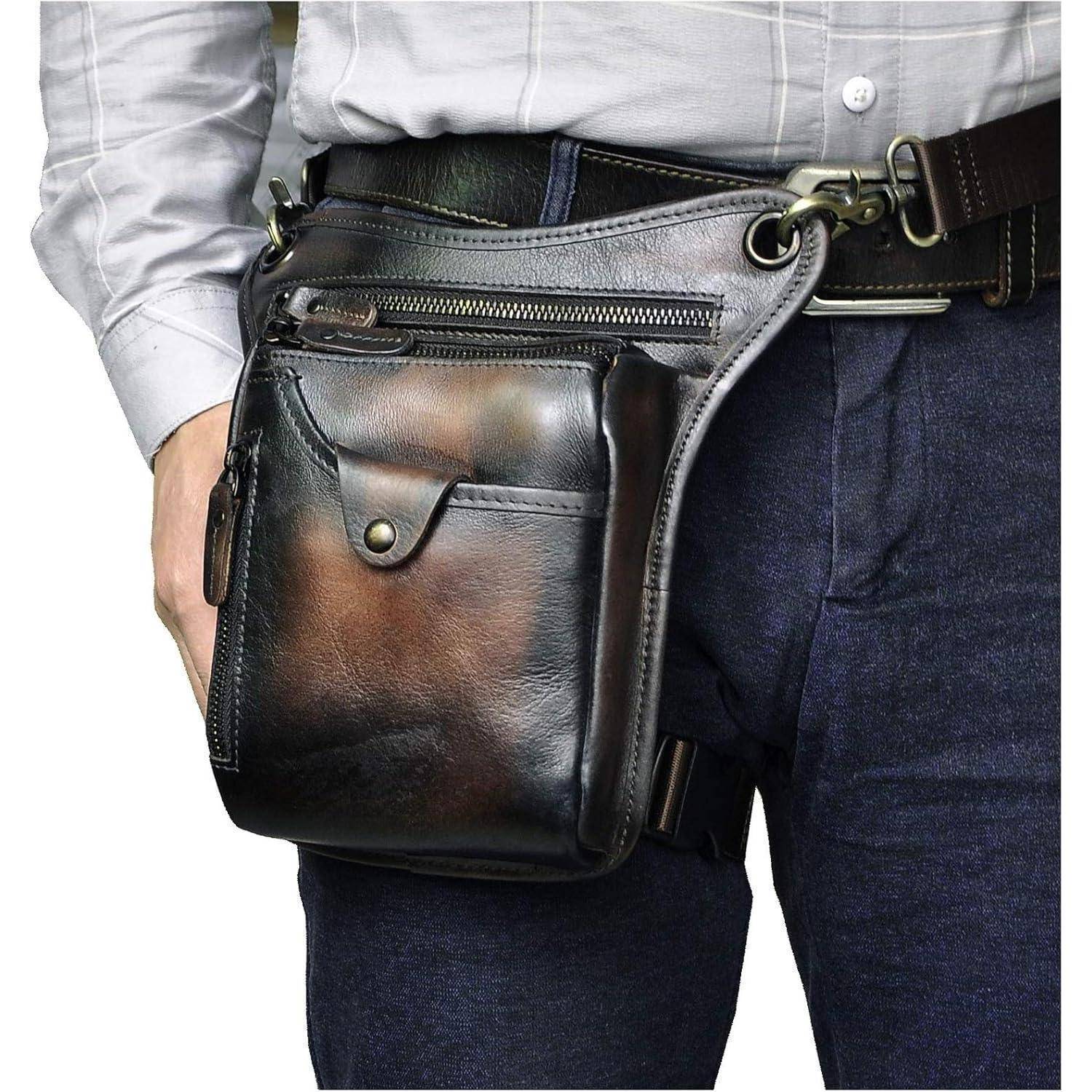 Nahaufnahme einer Person, die eine schwarze Ledertasche zum Umhängen mit Reißverschlusstaschen über einer Jeans und einem Gürtel trägt.