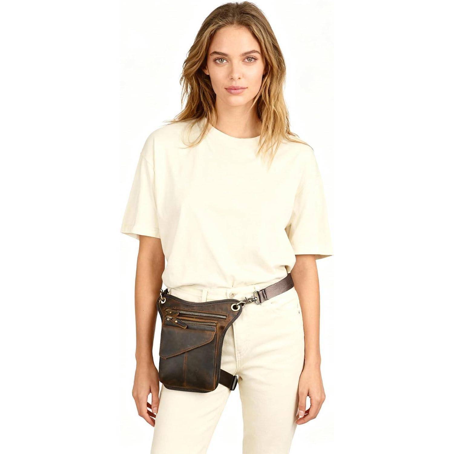 Frau, die ein übergroßes cremefarbenes T-Shirt und passende Hose mit einer dunklen Ledergürtel-Tasche vor weißem Hintergrund trägt.