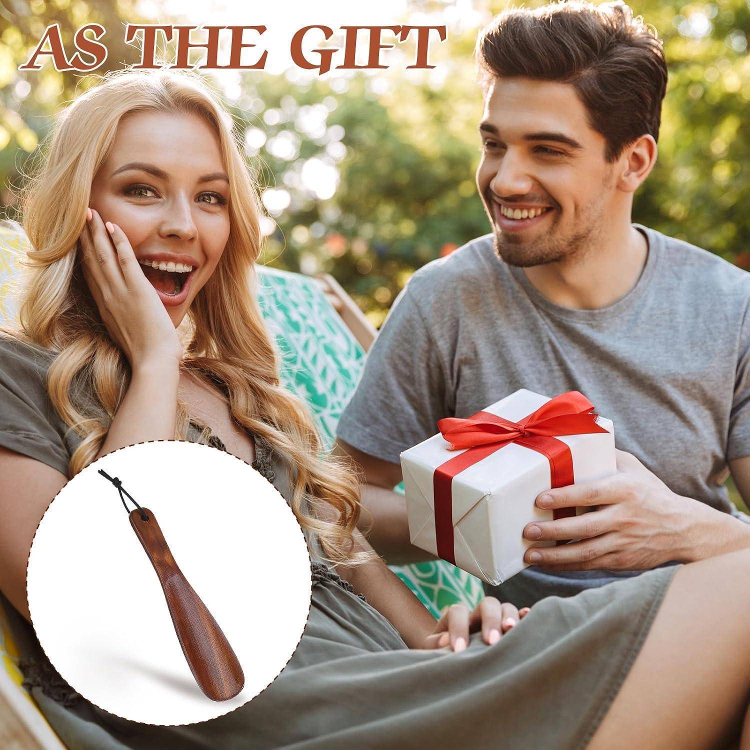 Ein lächelnder Mann gibt einer Frau ein verpacktes Geschenk im Freien, mit einem eingefügten Bild eines hölzernen Schuhanziehers. Der Text lautet „AS THE GIFT".
