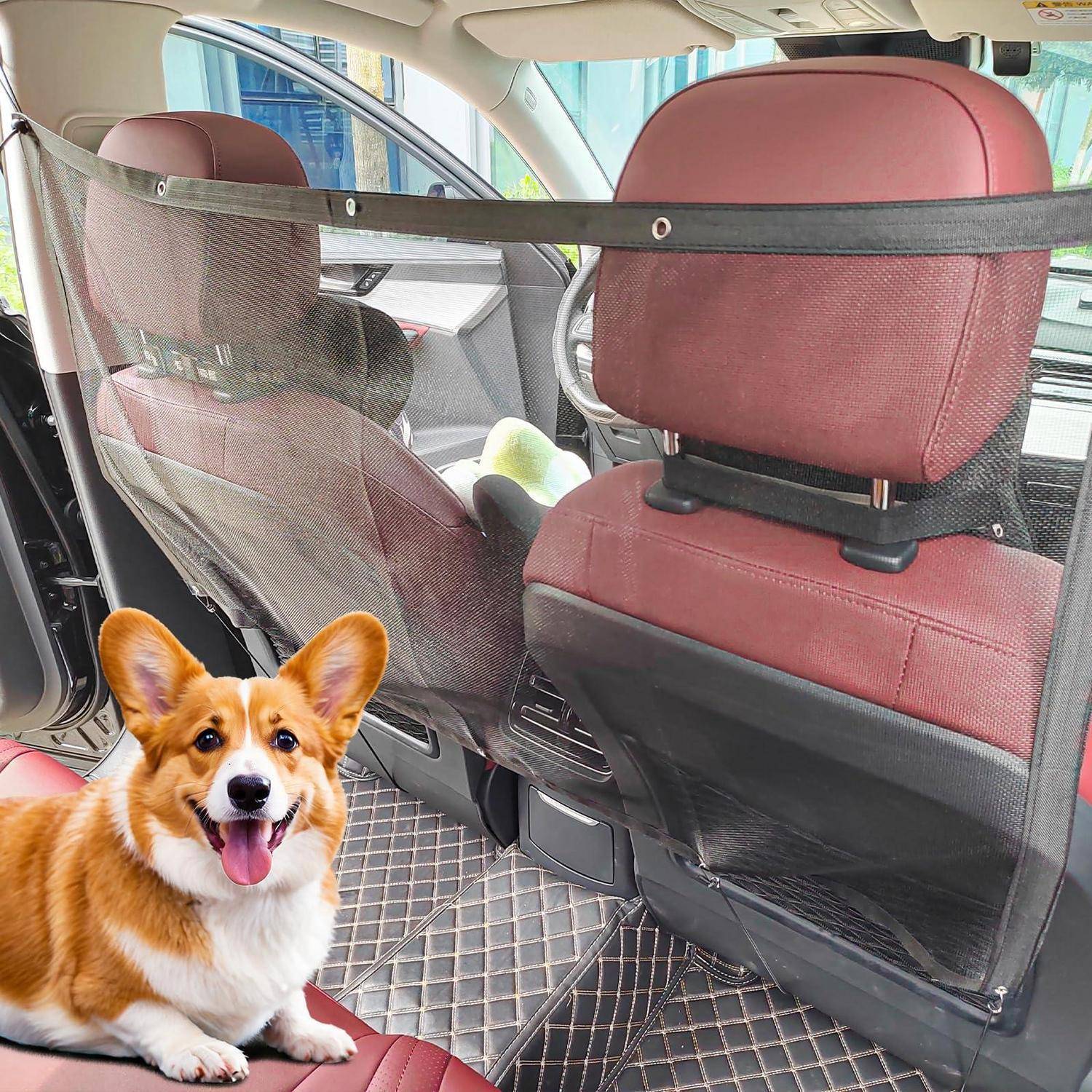 Ein kleiner Corgi sitzt auf einem Autositz neben einer Netz-Haustier-Barriere, mit roten Sitzbezügen und sichtbarem Autoinnenraum.