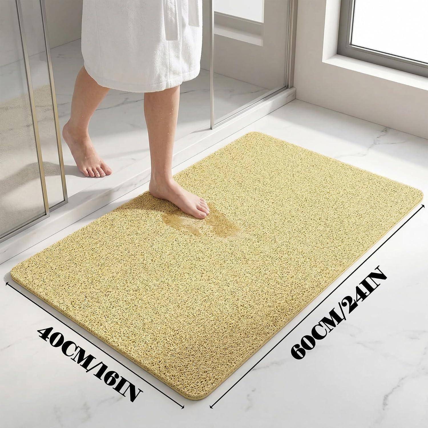 Gelbe Badematte im Badezimmer, gezeigt mit einem Fuß, der darauf tritt; Größe gekennzeichnet mit 40 cm x 60 cm.
