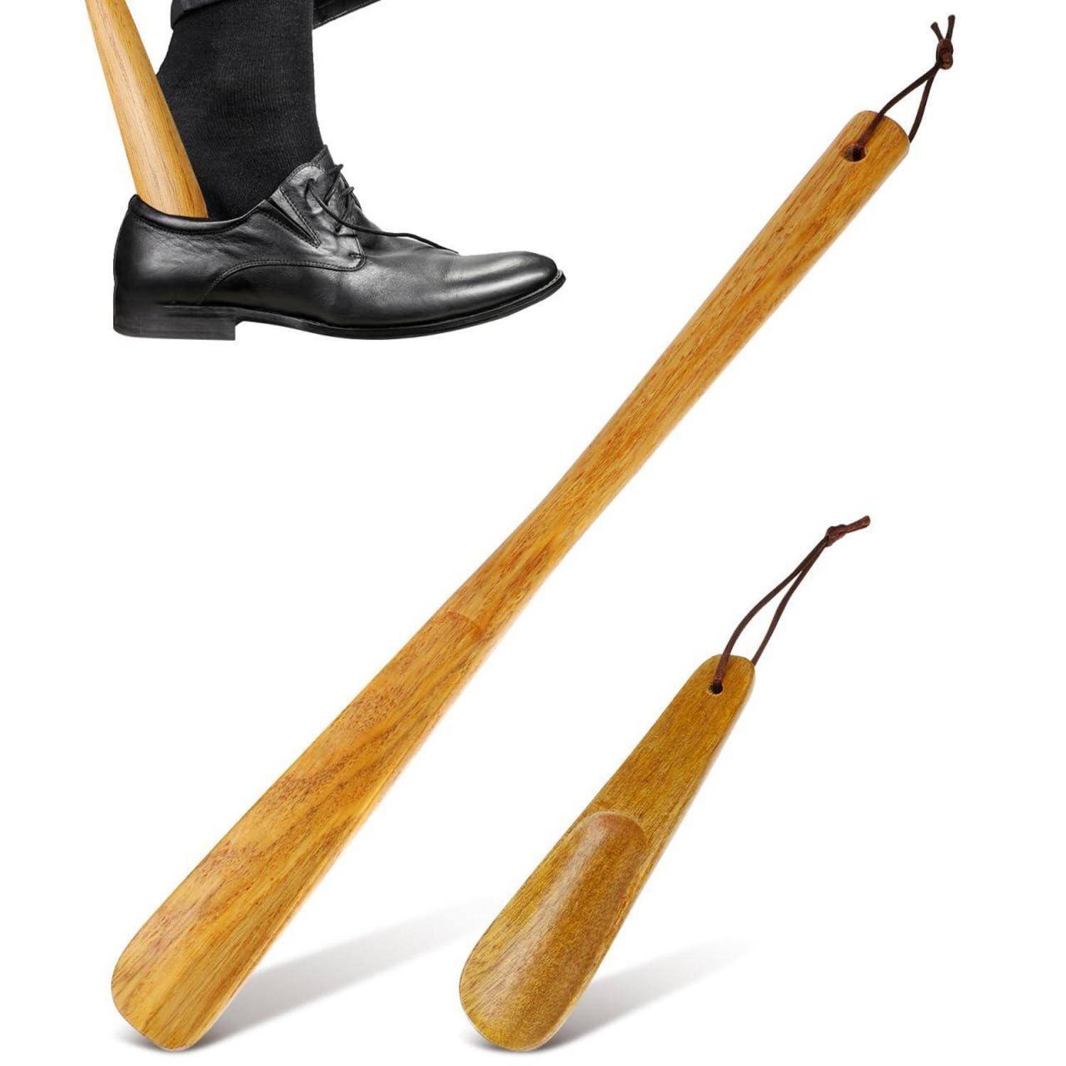 Holzerne Schuhlöffel, bestehend aus einem langen und einem kurzen, neben einem Schuh, der mit Hilfe des langen Schuhlöffels angezogen wird.