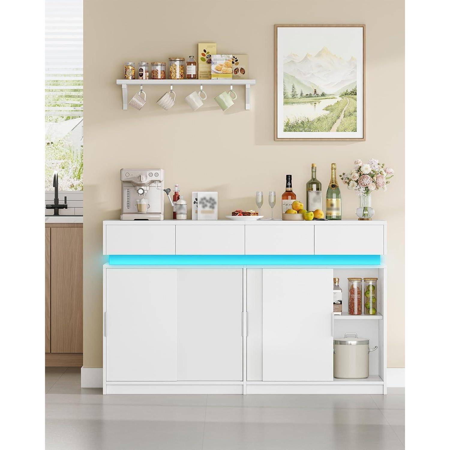 Modernes Küchenbuffet mit weißen Schränken, leuchtend blauem Unterschrankbeleuchtung, Kaffeemaschine, Flaschen, Obst, Gläsern, Blumen und Wandkunst darüber.