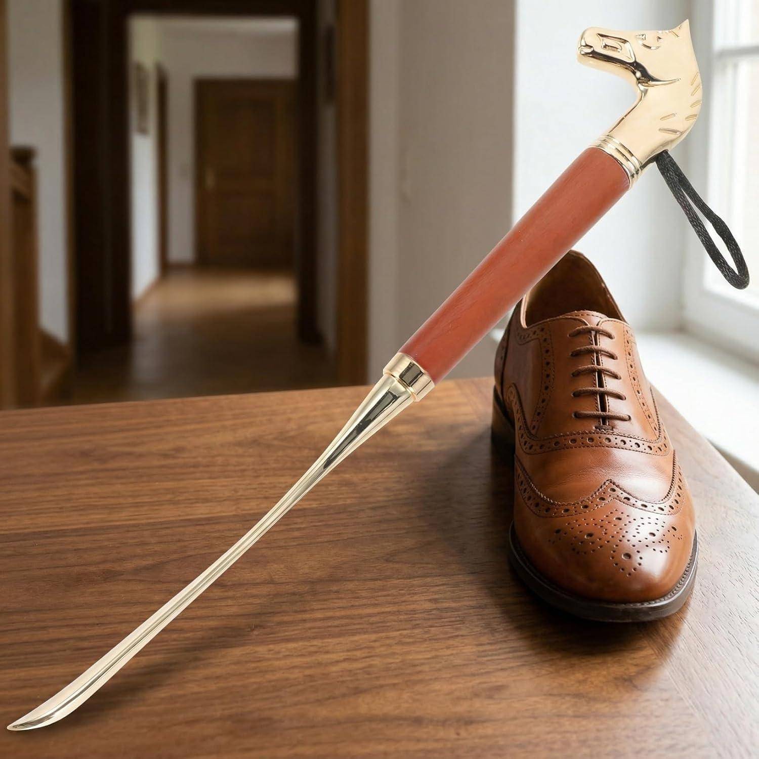 Ein polierter brauner Herrenschuh mit einem langstieligen Schuhlöffel, der auf einem Holztisch neben einem Fenster ruht.