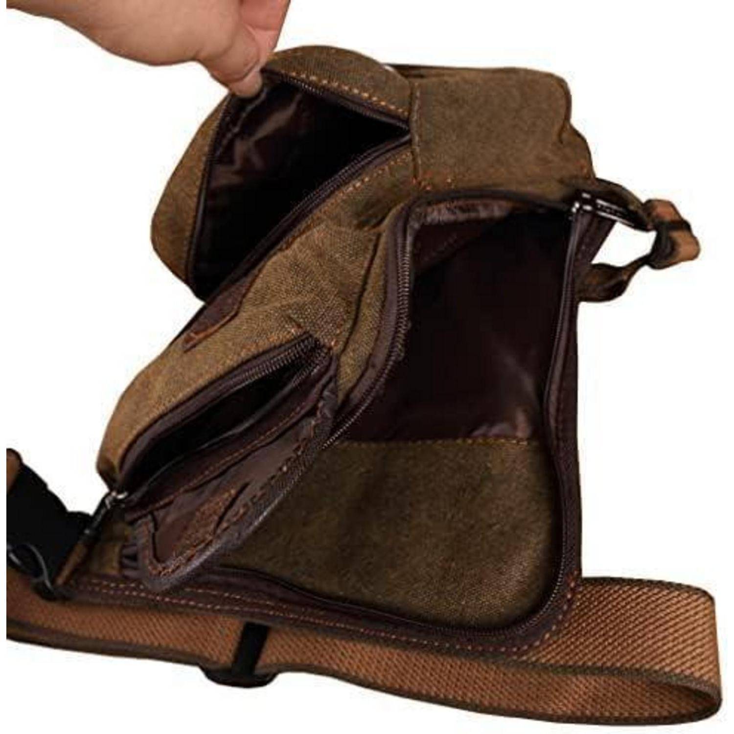 Offene braune Schultertasche mit mehreren Reißverschlussfächern, geöffnet und offen gehalten, um das Innere zu zeigen.