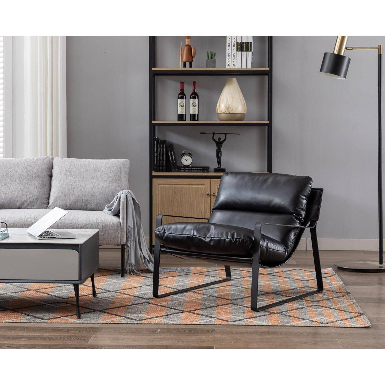 Modernes Wohnzimmer mit schwarzem Ledersessel, grauem Sofa, Couchtisch, Regalen und gemustertem Teppich.