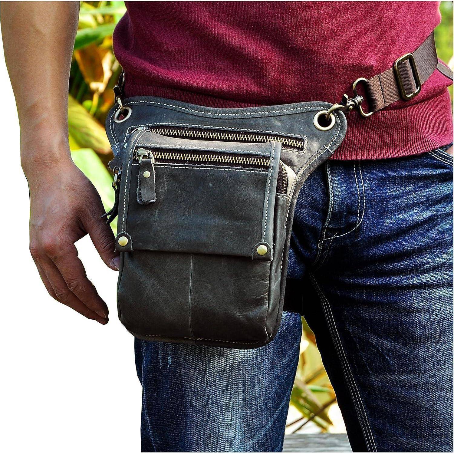 Nahaufnahme einer Person, die eine schwarze Ledergürtelholster oder kleine Umhängetasche an der Hüfte über einer Jeans und einem Bordeaux-Hemd trägt.