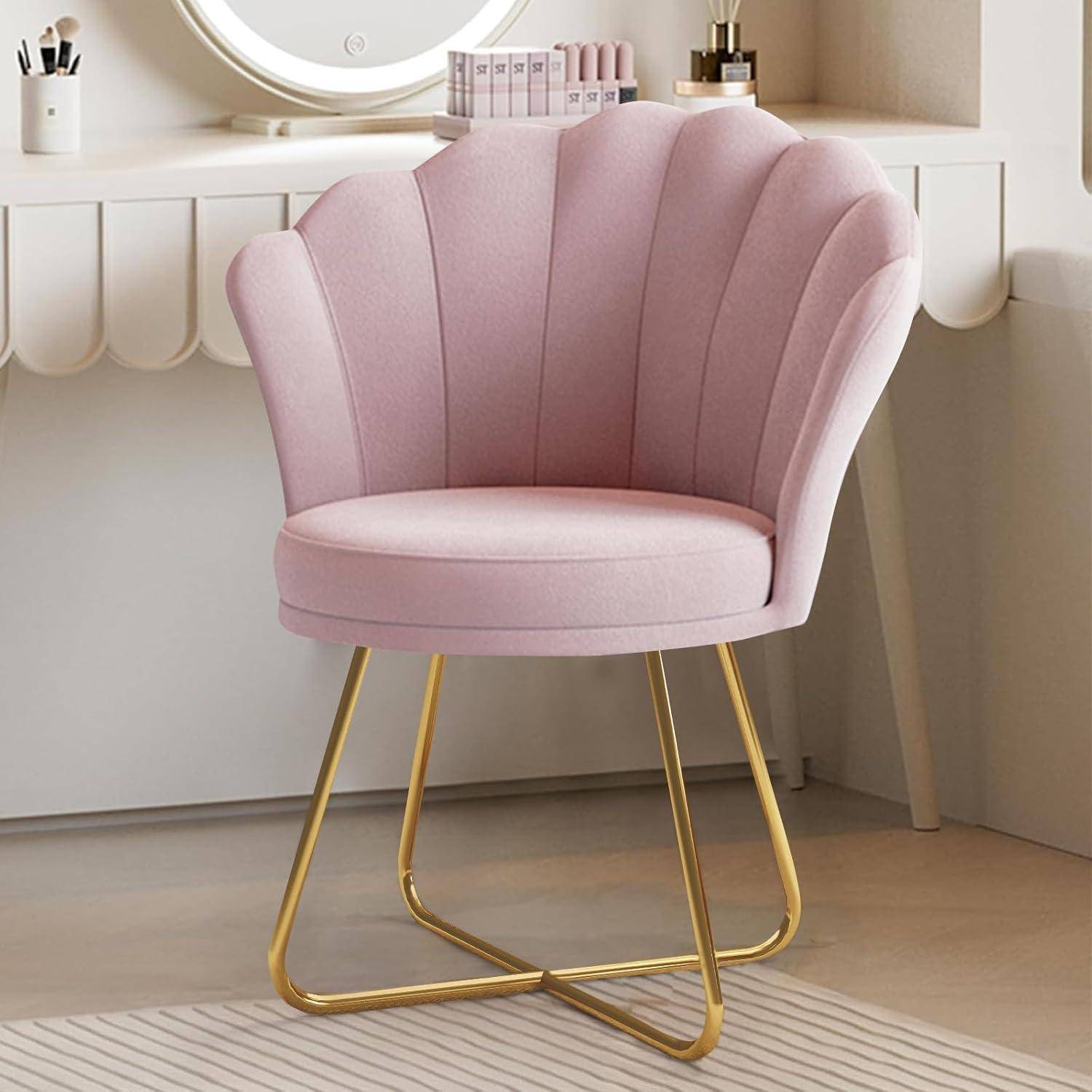 Rosa muschelförmiger gepolsterter Stuhl mit goldfarbenen Metallbeinen in einer Schminkecke neben einem weißen Schreibtisch und Spiegel.