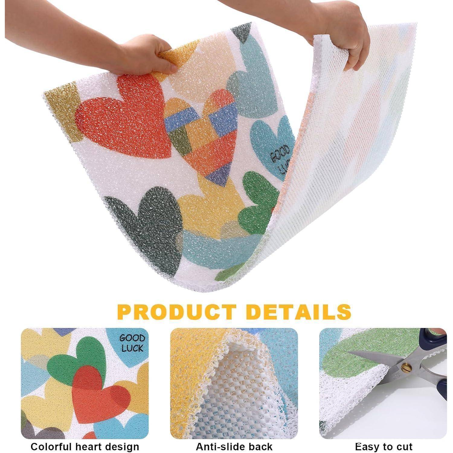 Produktdetail-Bild zeigt eine farbenfrohe Matte mit Herzenmuster und rutschfester Rückseite, die mit einer Schere geschnitten wird; Beschriftungen lauten „Buntes Herzdesign