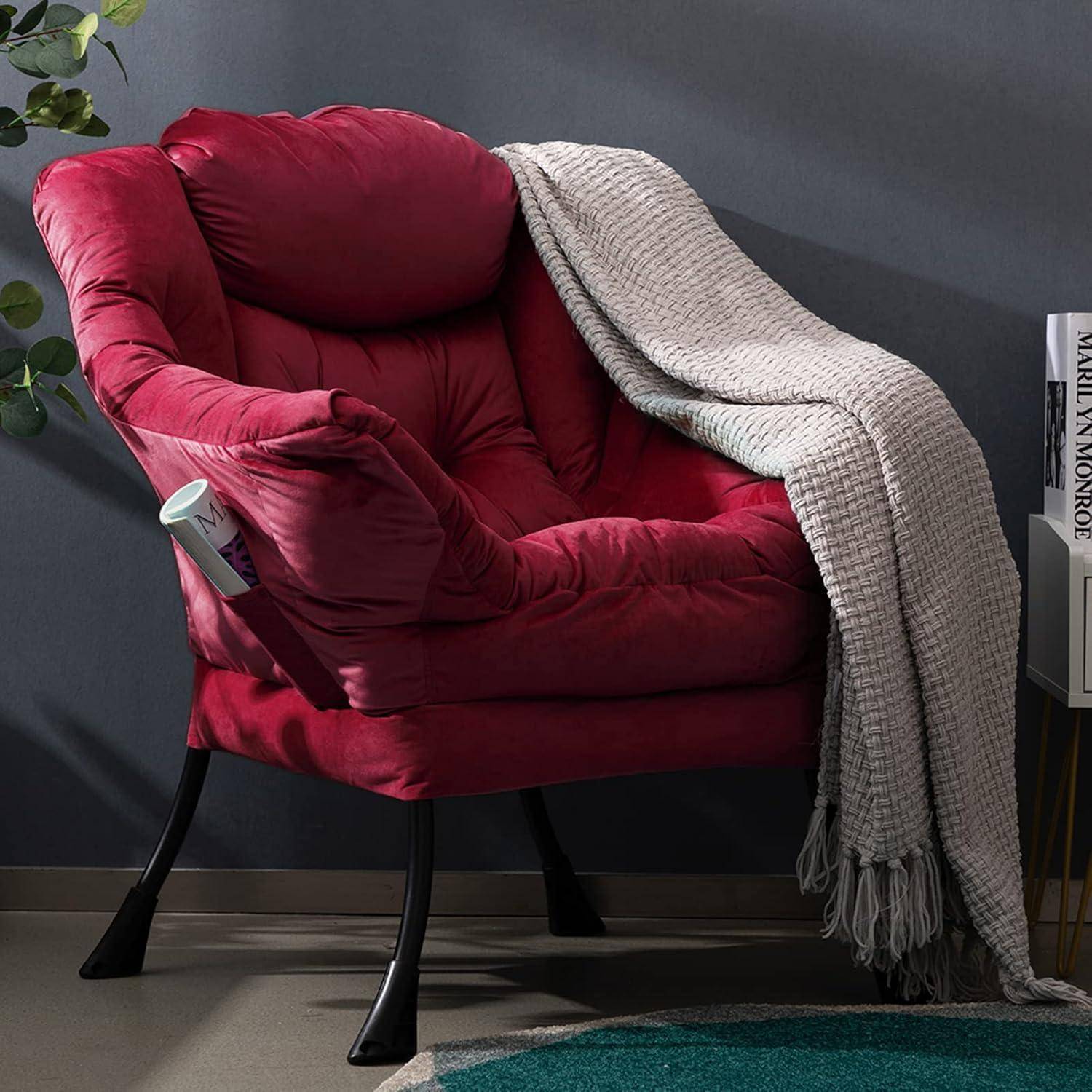 Ein rosafarbener Sessel mit Polsterung, über den eine cremefarbene Strickdecke drapiert ist, neben einer Wand und einem Bücherstapel.