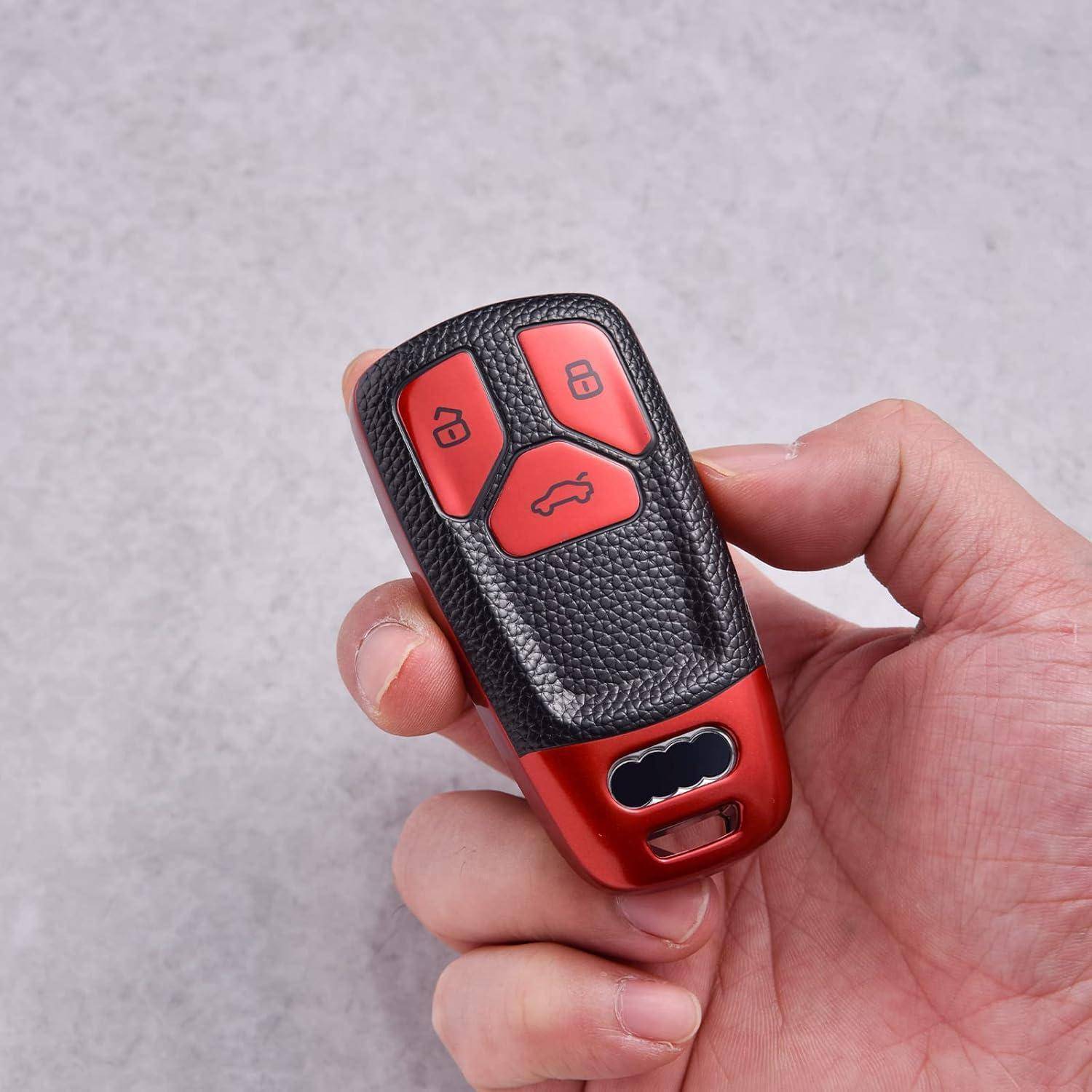 Hand, die eine rot und schwarze Autoschlüsselfernbedienung mit Verriegelungs-, Entriegelungs- und Kofferraumtasten hält.
