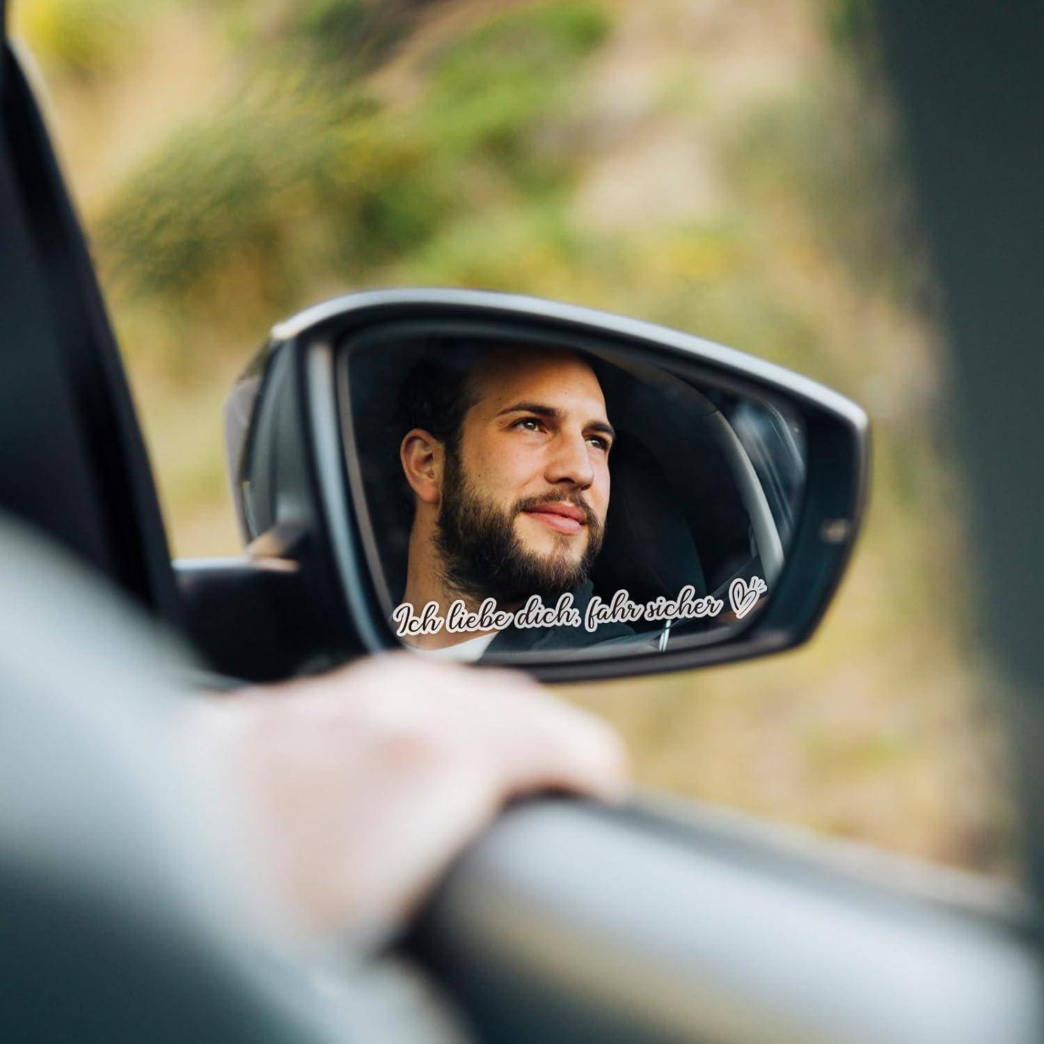 Gesicht eines Mannes, das sich in einem Seitenspiegel eines Autos widerspiegelt, mit der überlagerten Phrase „Ich liebe dich fahr sicher