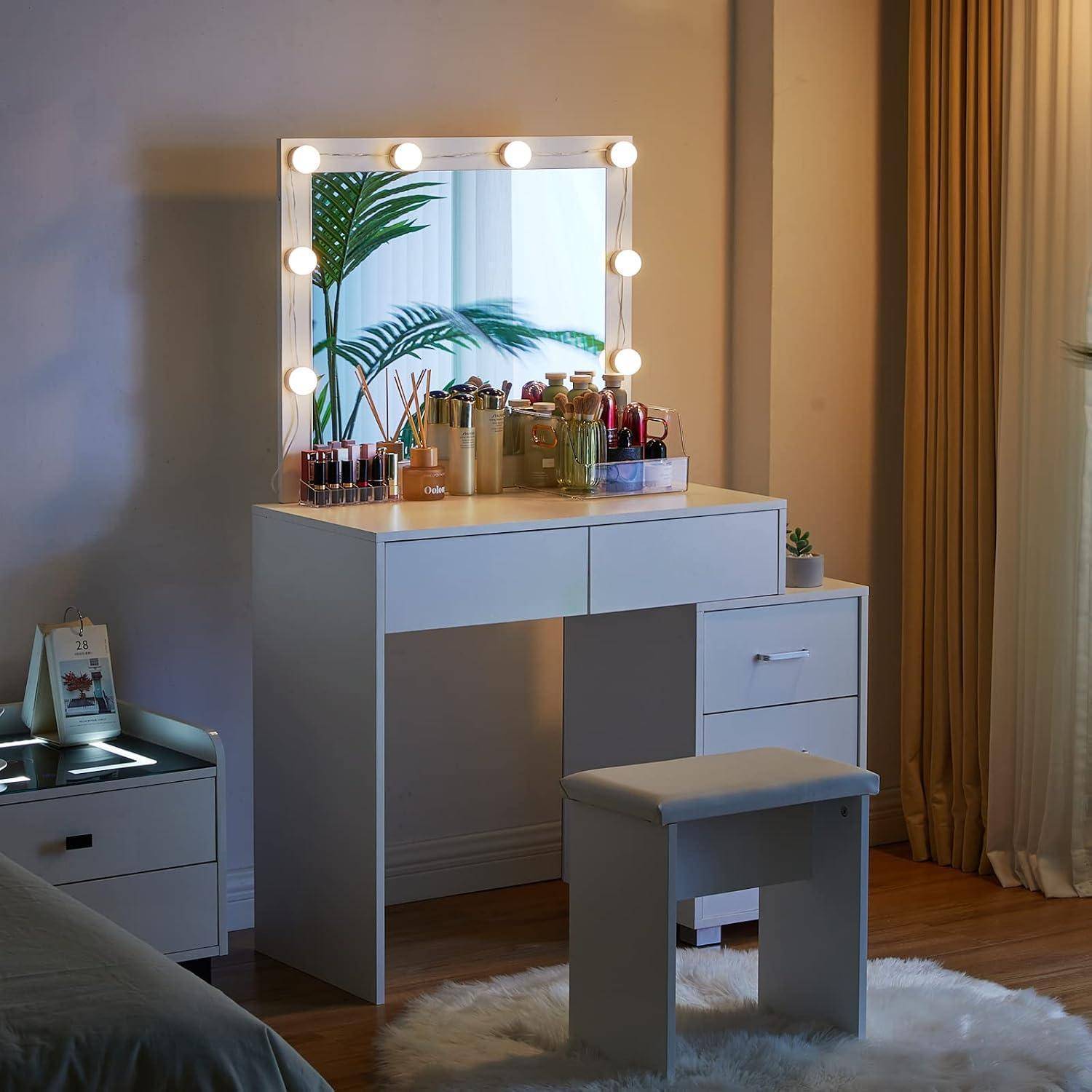 Frisiertisch mit beleuchtetem Spiegel, Kosmetikflaschen, Hocker und Pflanze in einem sanft beleuchteten Schlafzimmer.