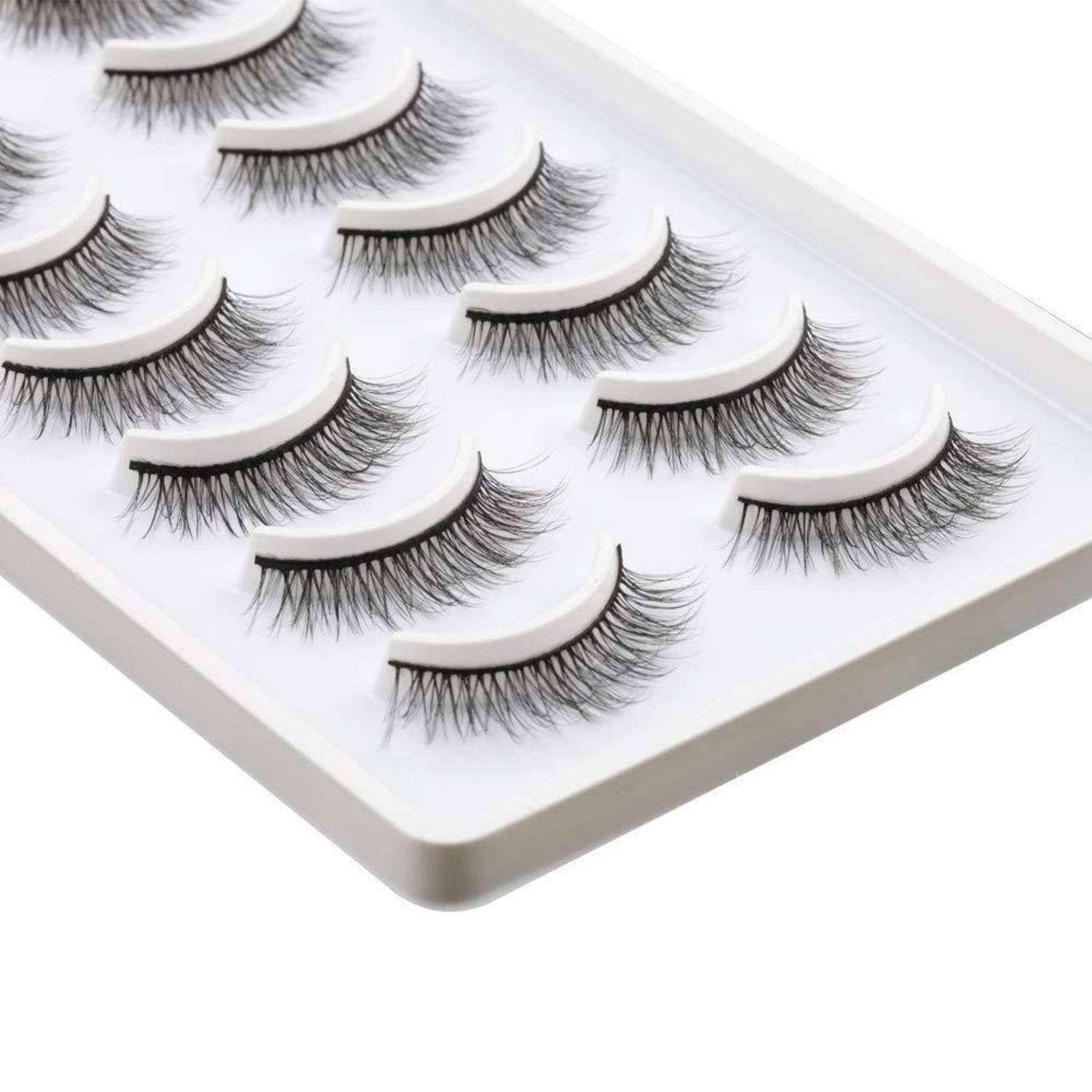 Tablett mit künstlichen Wimpern, die in Reihen auf einem weißen Displaybrett angeordnet sind.