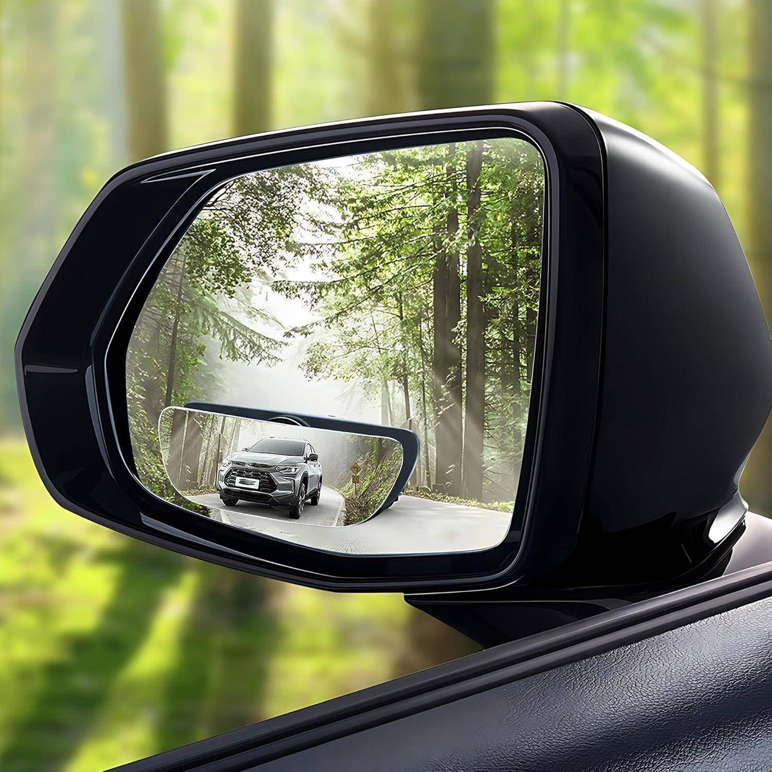 Autoseitenspiegel, der einen silbernen SUV zeigt, der auf einer gewundenen Waldstraße durch hohe Bäume und Nebel fährt.