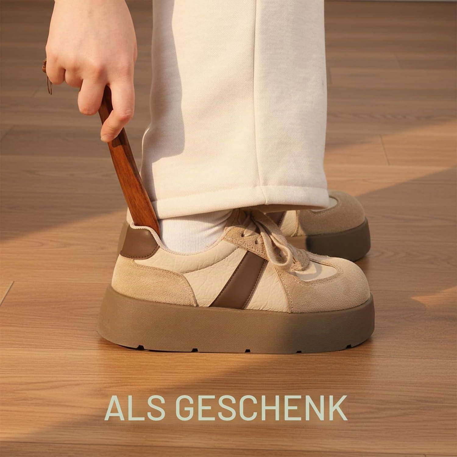 Person schlüpft mit einem Schuhanzieher in einen beigen Platform-Sneaker; Text lautet unten „ALS GESCHENK