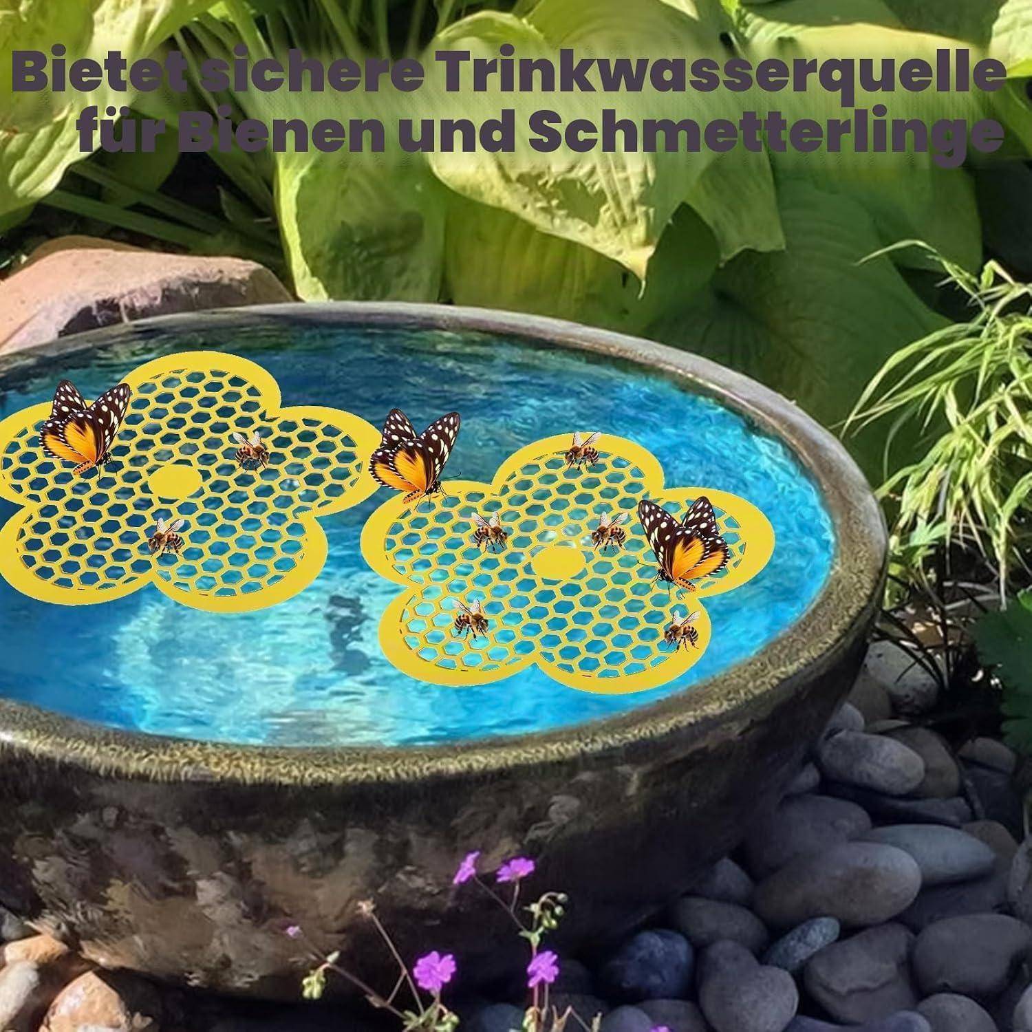 Vogelbad im Garten mit schwimmenden Bienen- und Schmetterlings-Wassersparmatten; deutscher Text besagt „Bietet sichere Trinkwasserquelle für Bienen und Schmetterlinge" (sichere Trinkwasserquelle für Bienen und Schmetterlinge).
