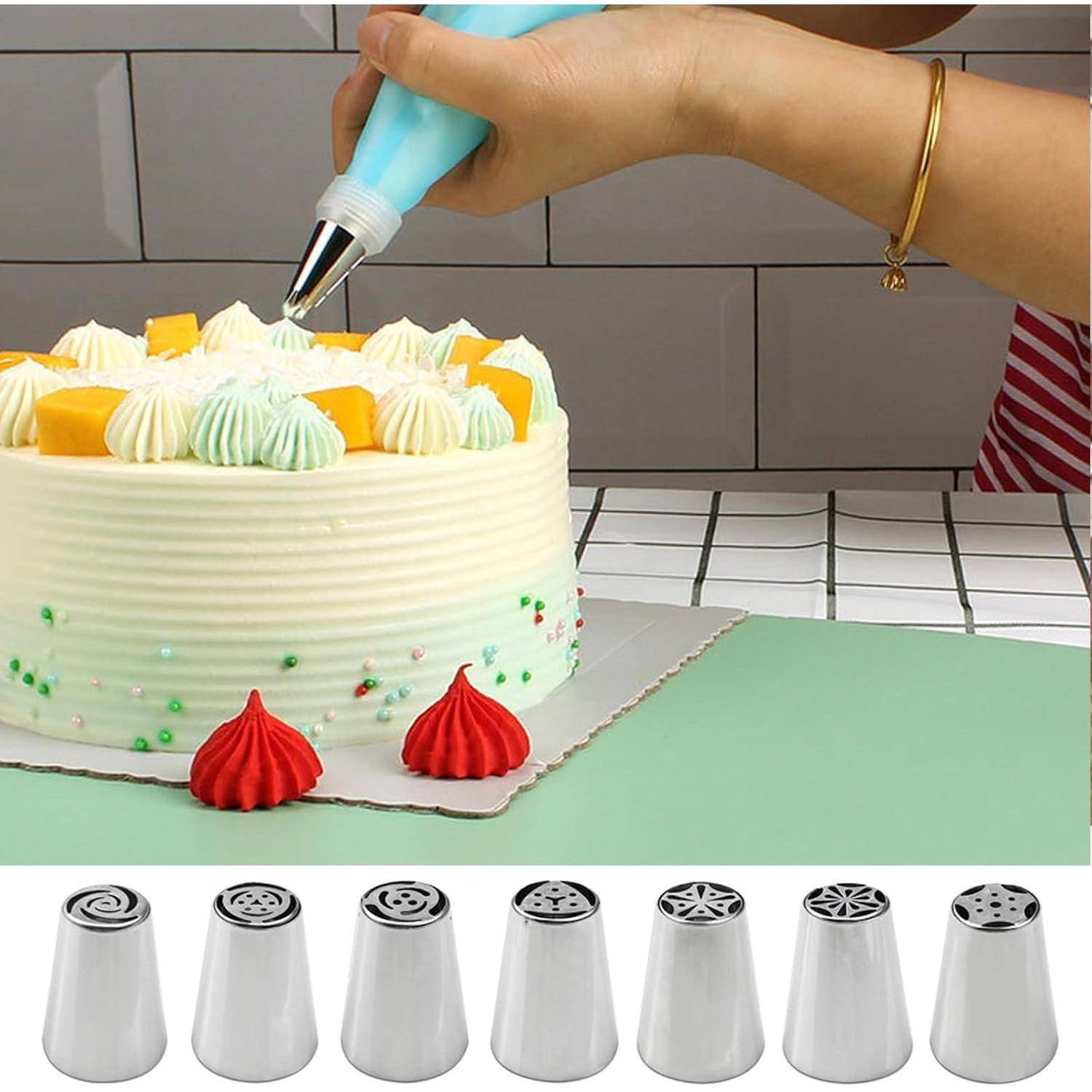 Das Aufspritzen von Zuckerguss mit einem Spritzbeutel auf einen dekorierten Kuchen, daneben ein Set von Metallspritzdüsen darunter angeordnet.