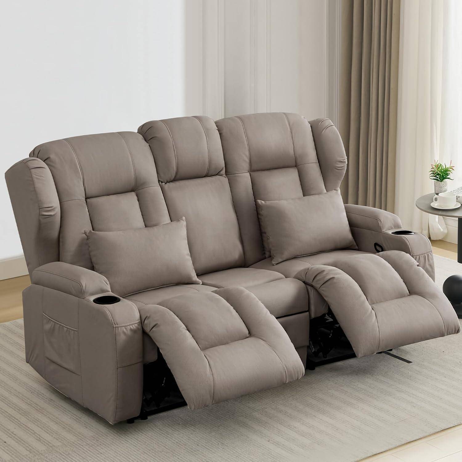 Graues dreiSitziges Liegesofa mit zwei Getränkehaltern und ausziehbaren Fußstützen in einem hellen Wohnzimmer.