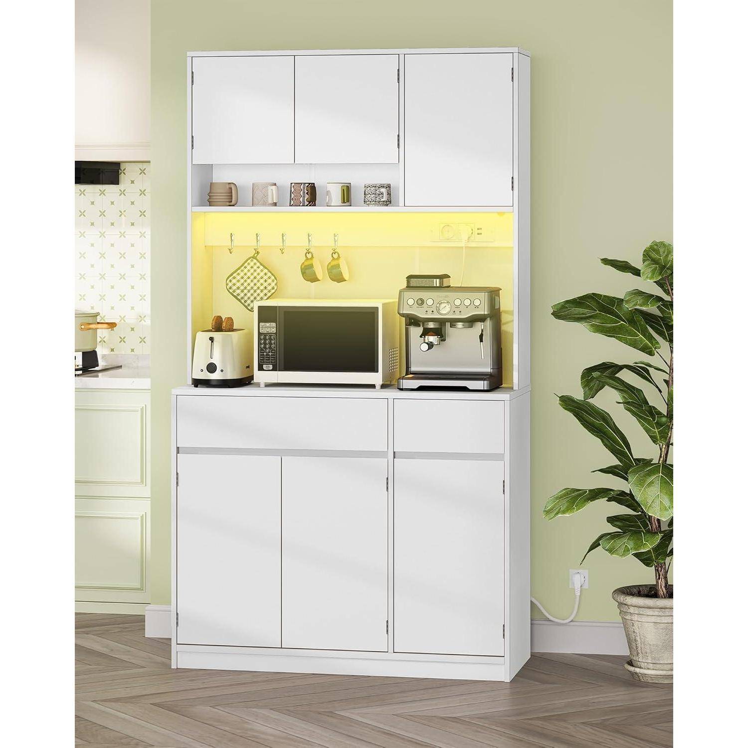 Weißer Küchenschrank mit oberen und unteren Türen, beleuchtetes offenes Regal mit einer Mikrowelle, einem Toaster und einer Kaffeemaschine, neben einer Topfpflanze.