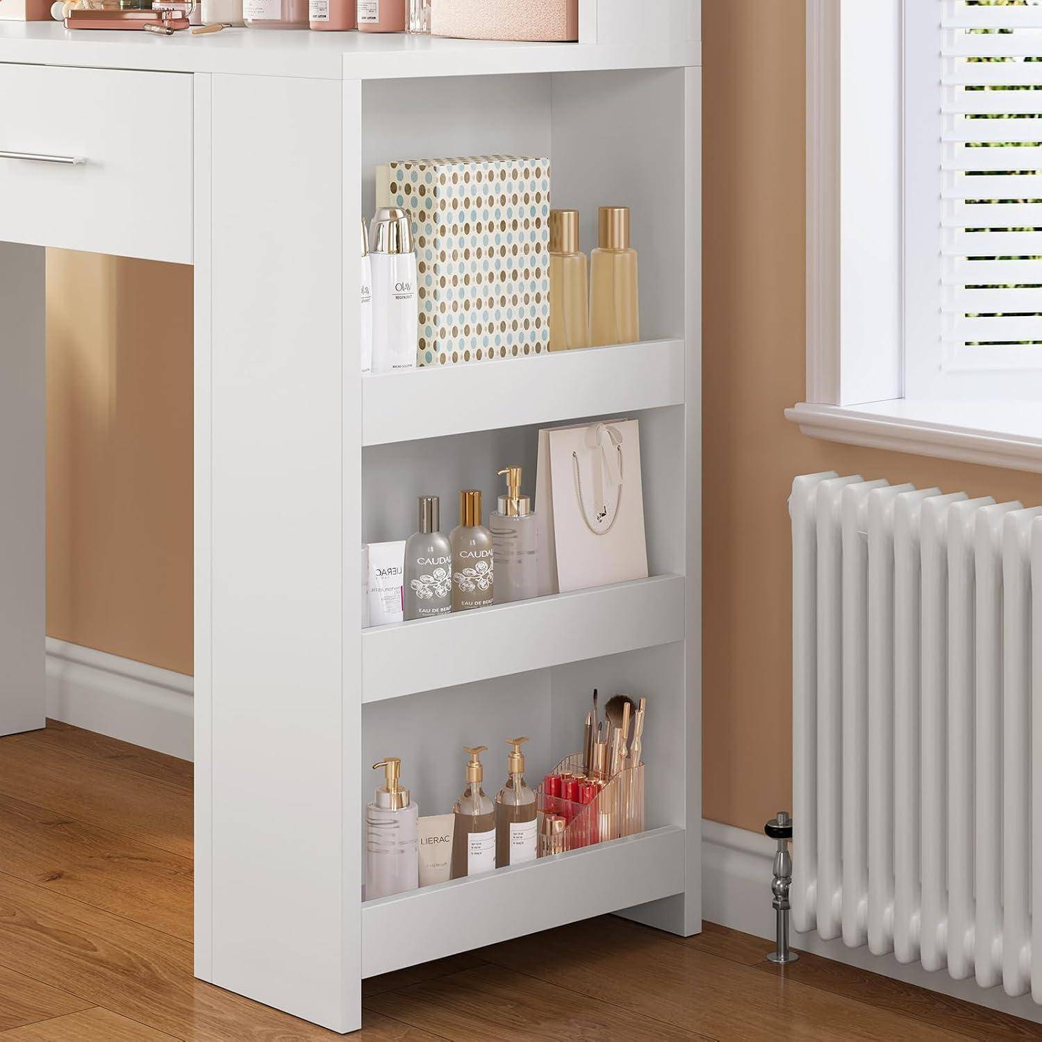 Weiße Regalanlage in einem Zimmer, die verschiedene Parfümflaschen, Schönheitsprodukte und eine Geschenktüte neben einem Fenster und einer Heizung hält.