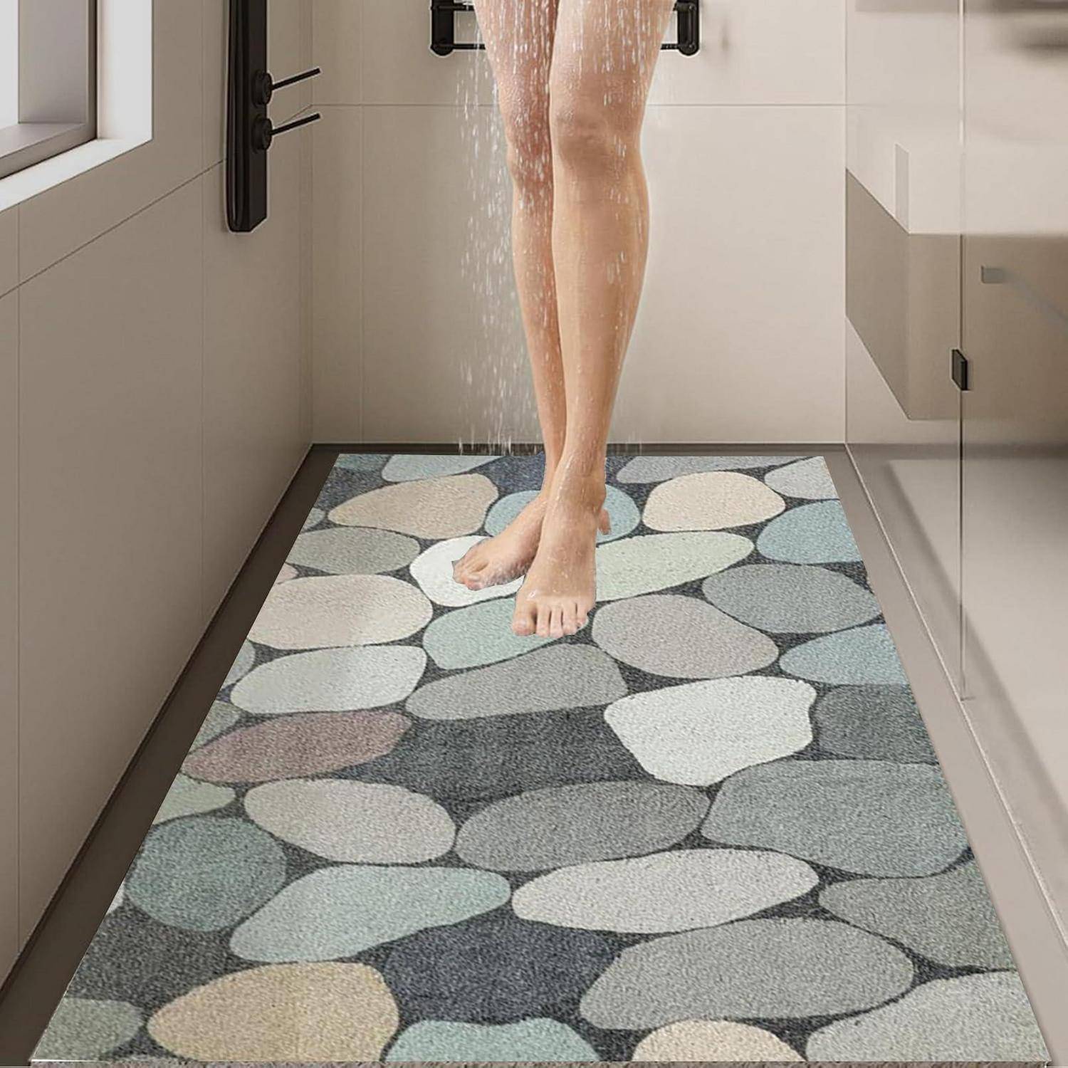 Person in the shower, mit Wasser, das über nackten Beinen auf eine Badematte mit Kieselsteinmuster in einem modernen Badezimmer läuft.