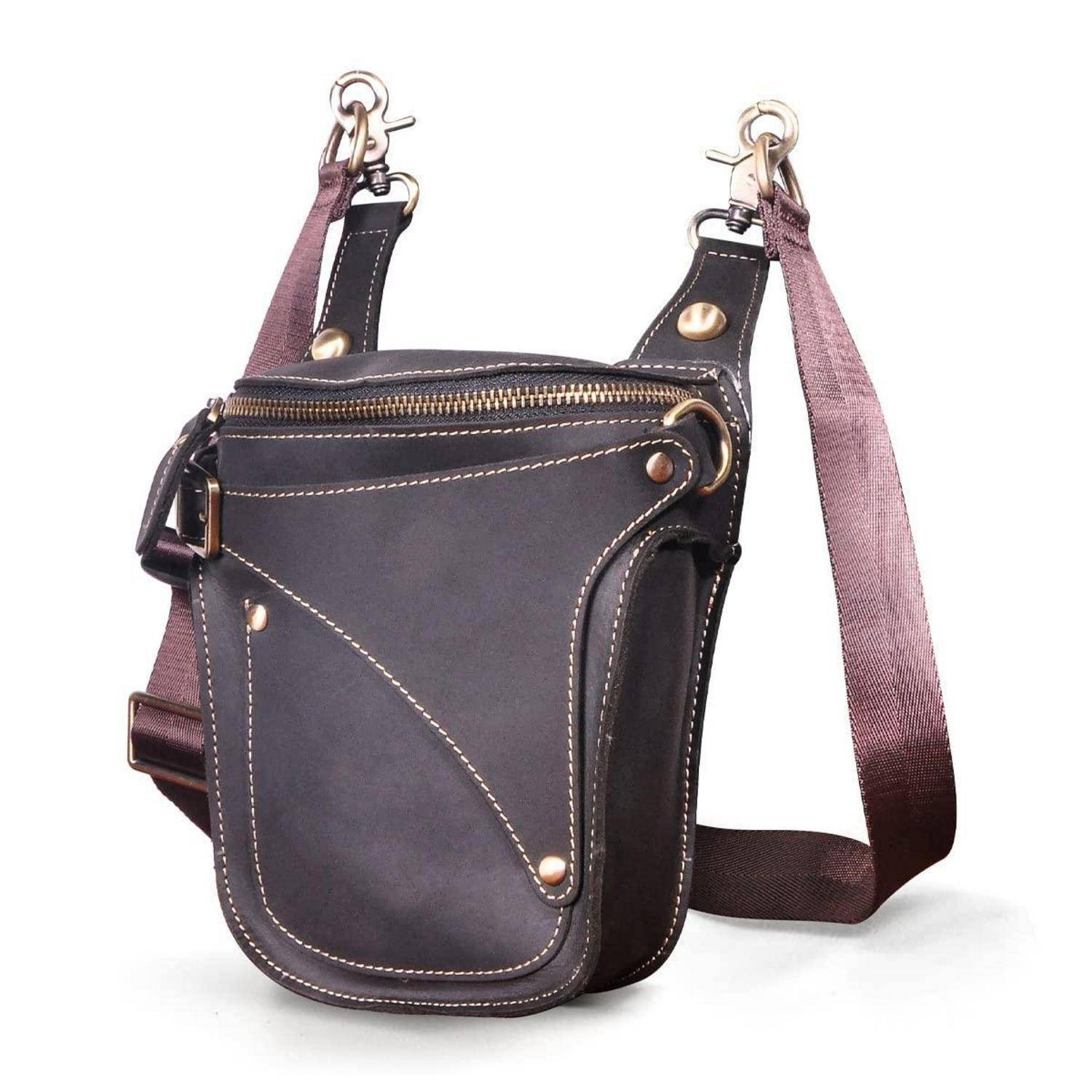 Braune Ledertasche mit Schultergurt und Brusttasche mit frontalem Reißverschluss, Messingbeschlägen und verstellbarem Schultergurt auf weißem Hintergrund.