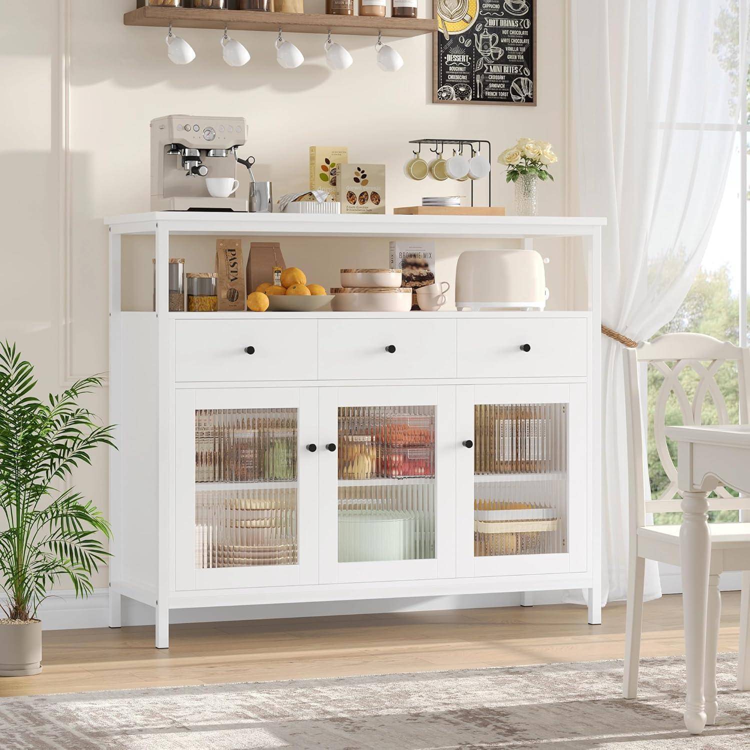 Weiße Küchensideboard mit Glastürschränken, Arbeitsplatte Küchengeräte und ausgestelltes Geschirr in einem hellen Essbereich.