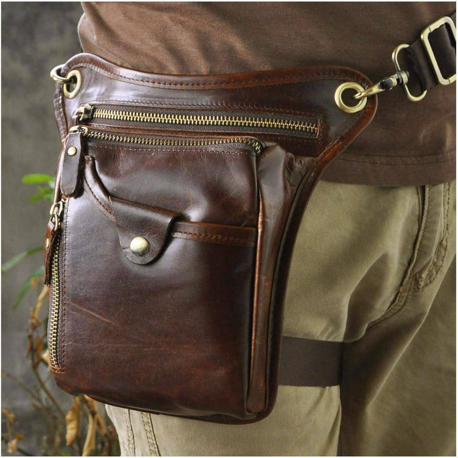 Braunes Ledergürteltasche mit mehreren Reißverschlusstaschen und Messingbeschlägen, an der Hüfte einer Person getragen, die hellbraune Hose trägt.