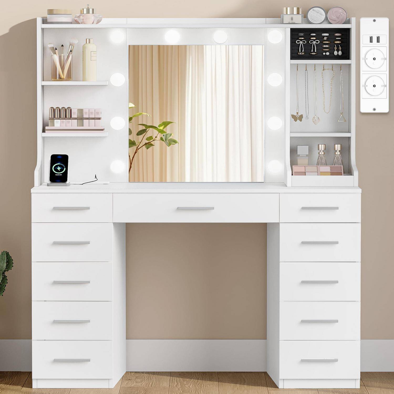 Weißer Frisiertisch mit Spiegel und runden Leuchten, offene Regale für Kosmetik und Schmuck und mehrere Schubladen in einem beigen Zimmer.