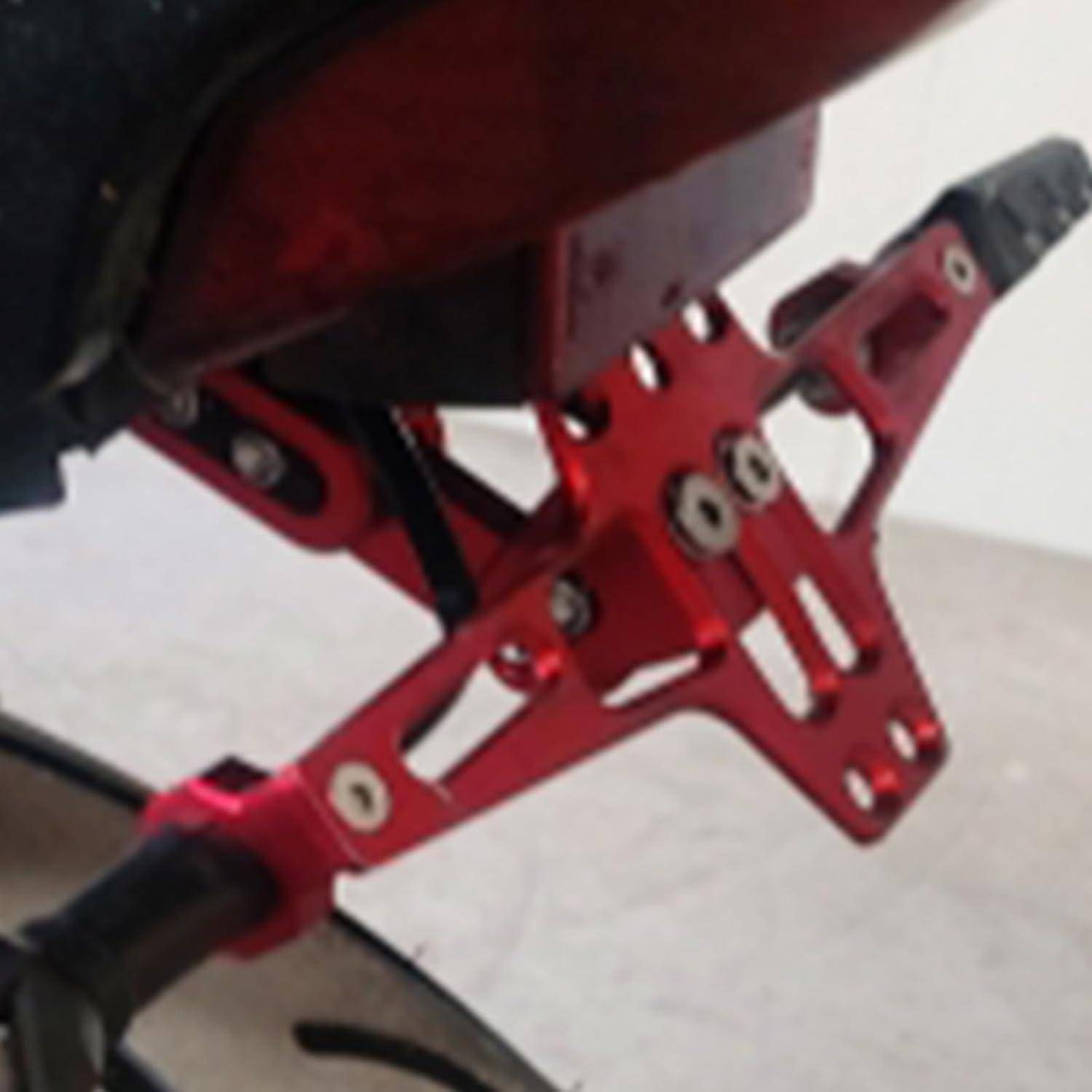 Nahaufnahme einer roten Metall-Aufhängungslenkstange mit Bolzen und Gelenken, die an einem Motorrad- oder Fahrradrahmen befestigt ist.