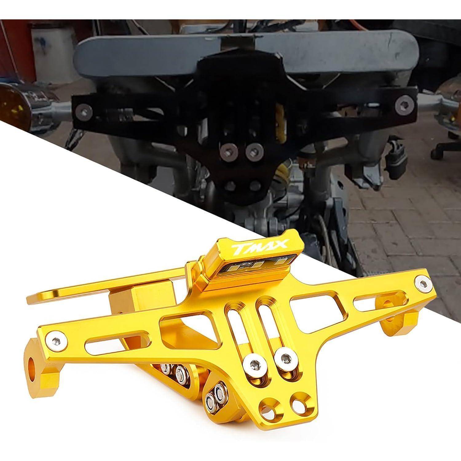 Goldanodisierte Motorrad-Heckhalterung mit 'TMX'-Logo, dargestellt vor einer Fahrrad-Hinterradmontage auf weißem Hintergrund.
