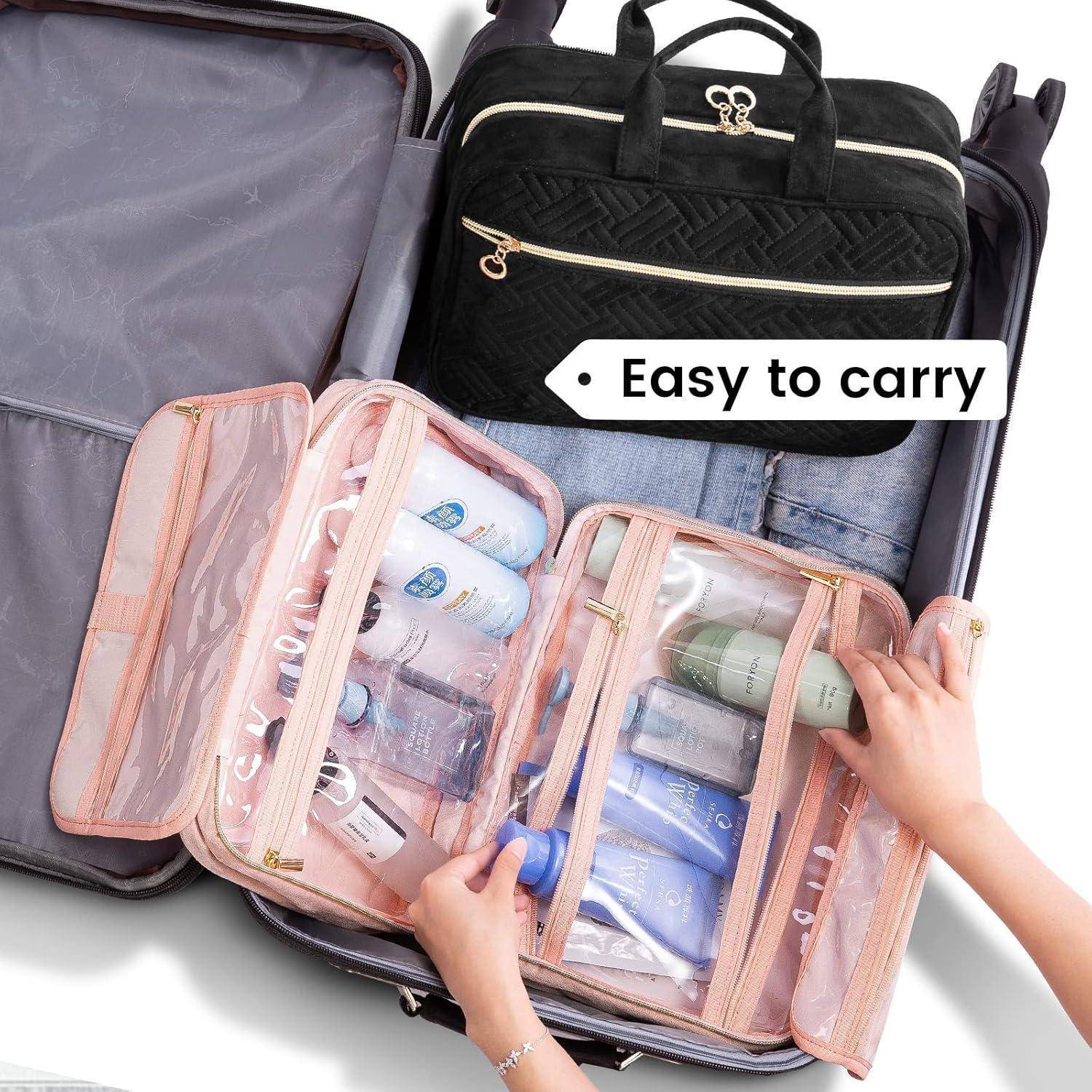 Offener Koffer mit drei durchsichtigen rosa Kosmetiktaschen und einer schwarzen Handtasche; das Etikett sagt „Leicht zu tragen