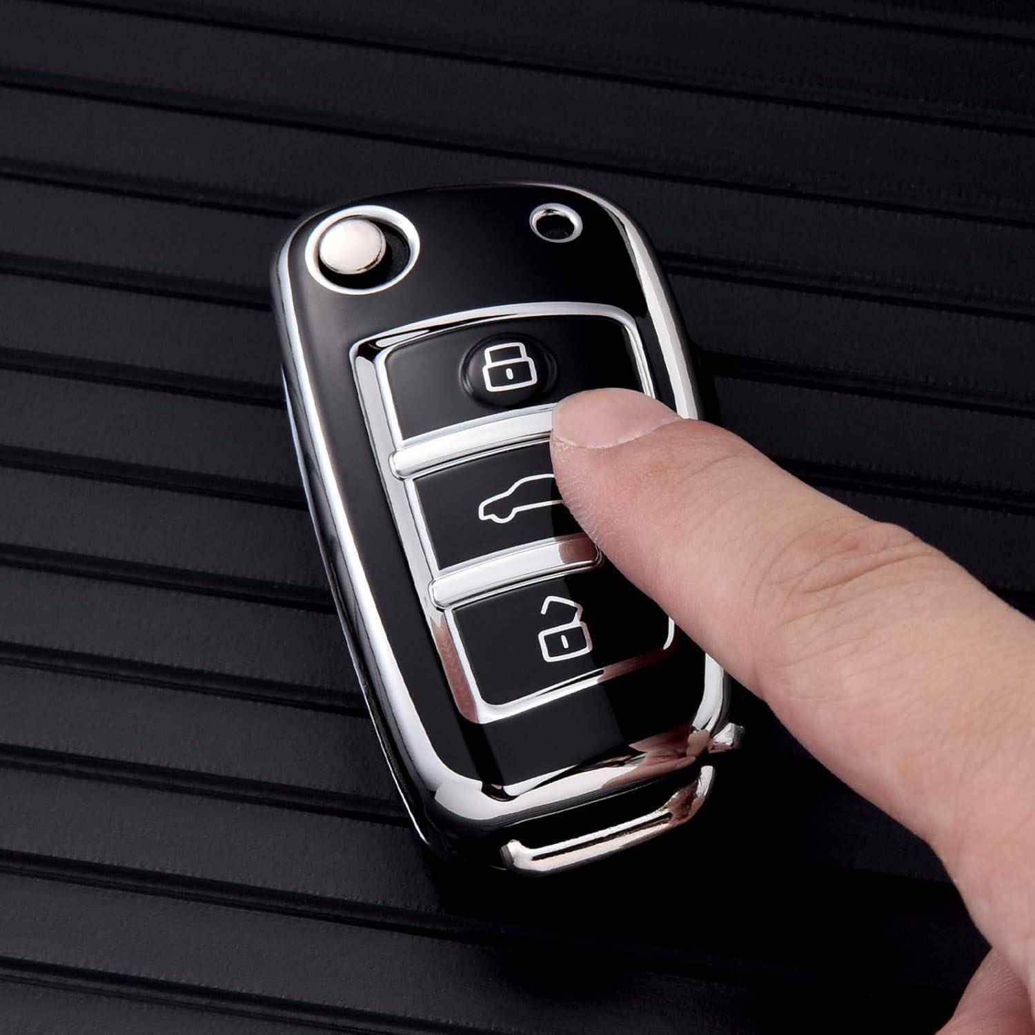 Nahaufnahme einer Hand, die die mittlere Taste an einem Autoschlüsselbund drückt, wahrscheinlich die Kofferraumentriegelung, mit sichtbaren Verriegelungs- und Entriegelungstasten.