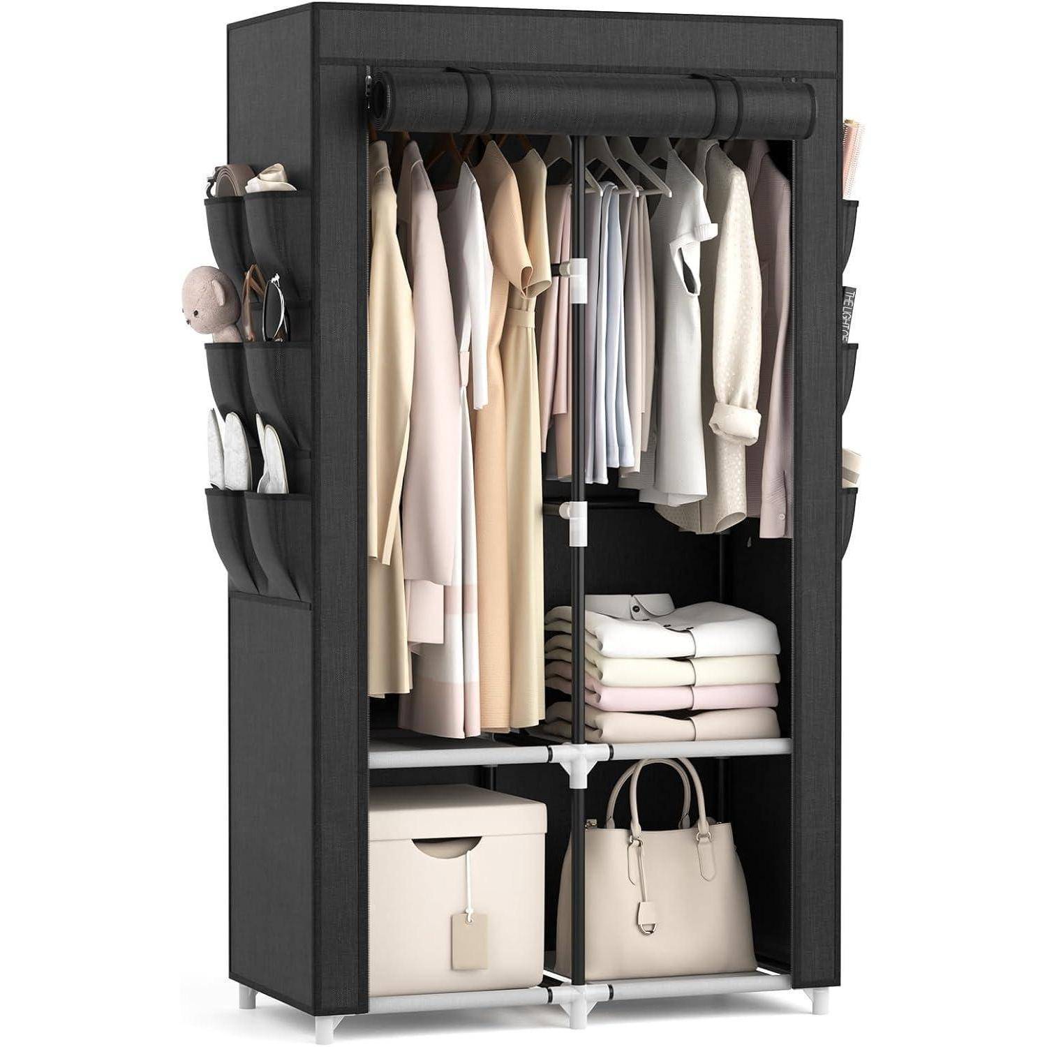 Tragbarer Kleiderschrank aus schwarzem Stoff mit hängender Kleidung, Regalen mit gefalteten Betttüchern, Aufbewahrungsboxen und Seitentaschen für Accessoires.