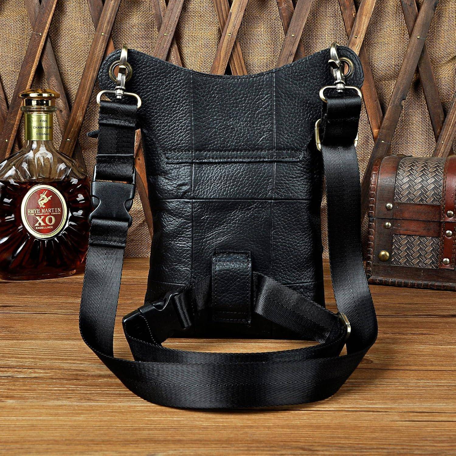 Schwarze Ledertasche mit Schultergurt mit verstellbarem Riemen, gezeigt auf einer Holzoberfläche vor einem gewebten Hintergrund.