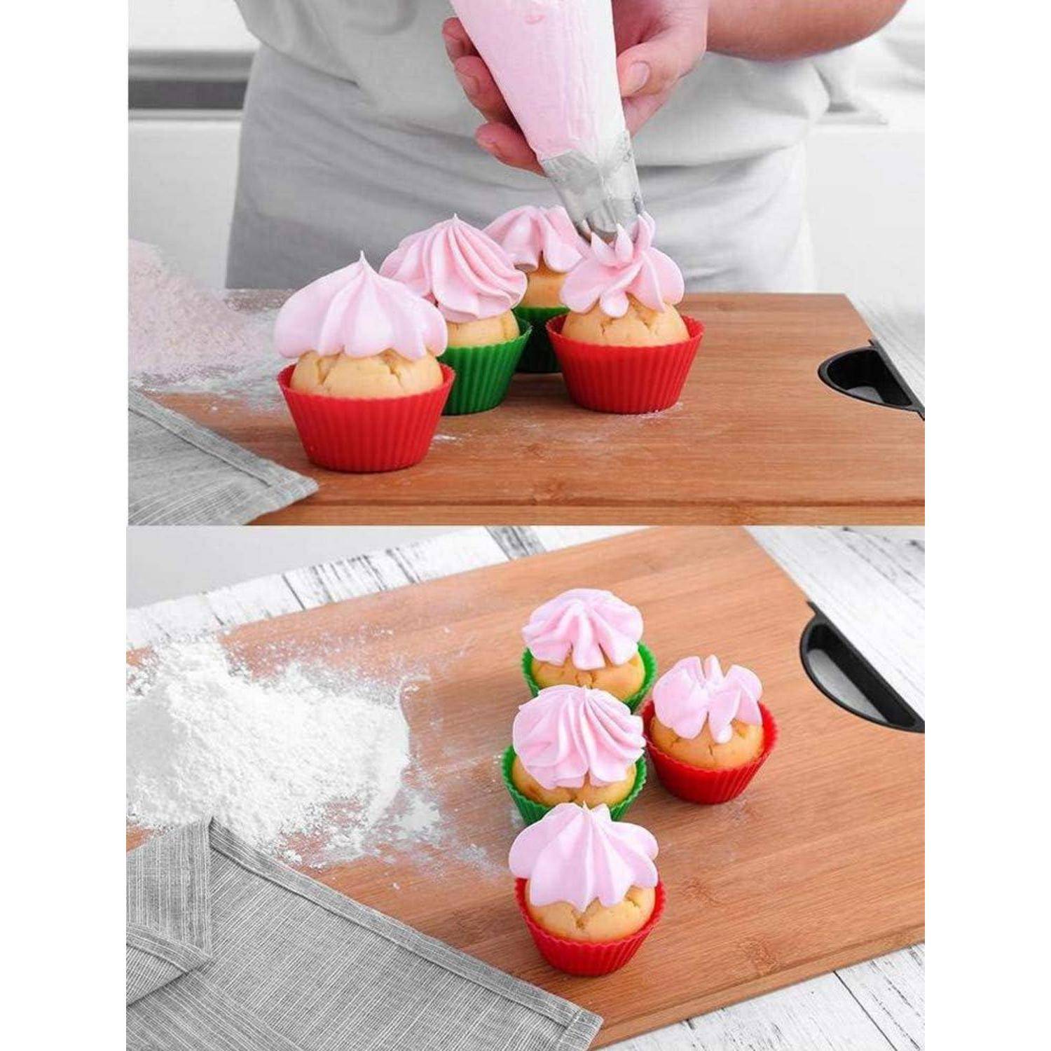 Ein Bäcker spritzt rosafarbenes Frosting auf Cupcakes in farbenfrohen Papiermanschetten auf einem Holzbrett.