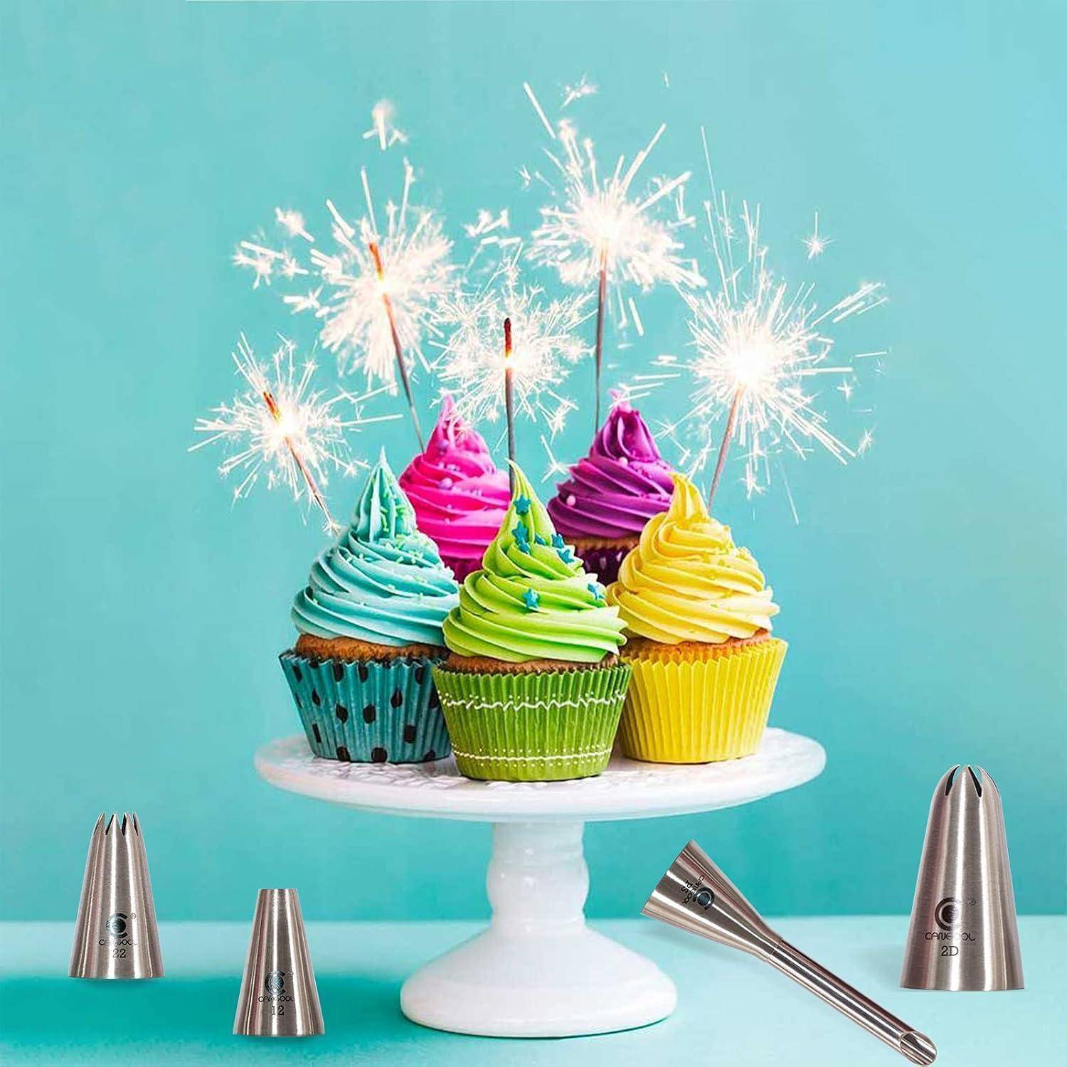 Fünf bunte Cupcakes auf einem weißen Kuchenständer mit brennenden Wunderkerzen vor einem türkisfarbenen Hintergrund.