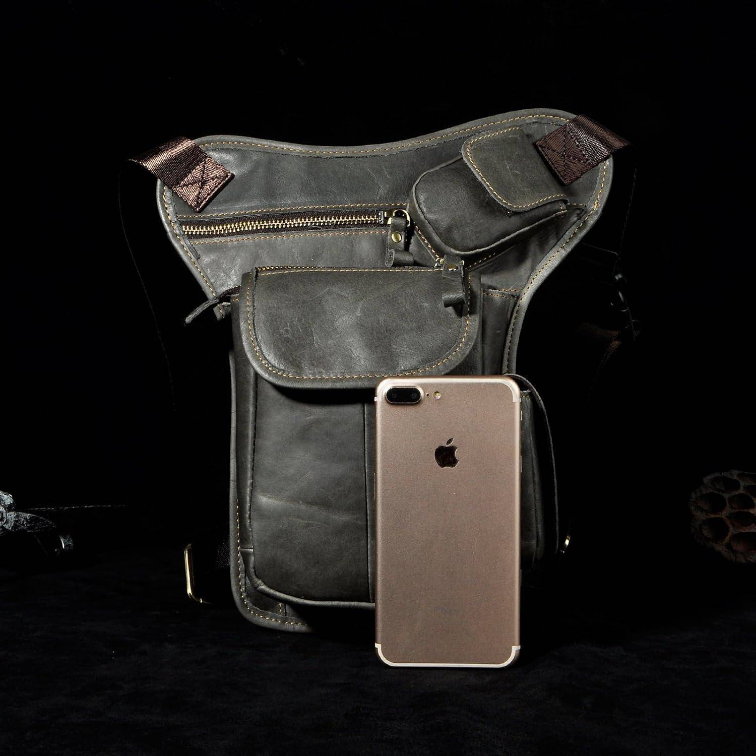 Dunkelgraue Ledertasche mit Schultergurt und mehreren Reißverschlusstaschen, gezeigt hinter einem goldenen iPhone zum Größenvergleich.