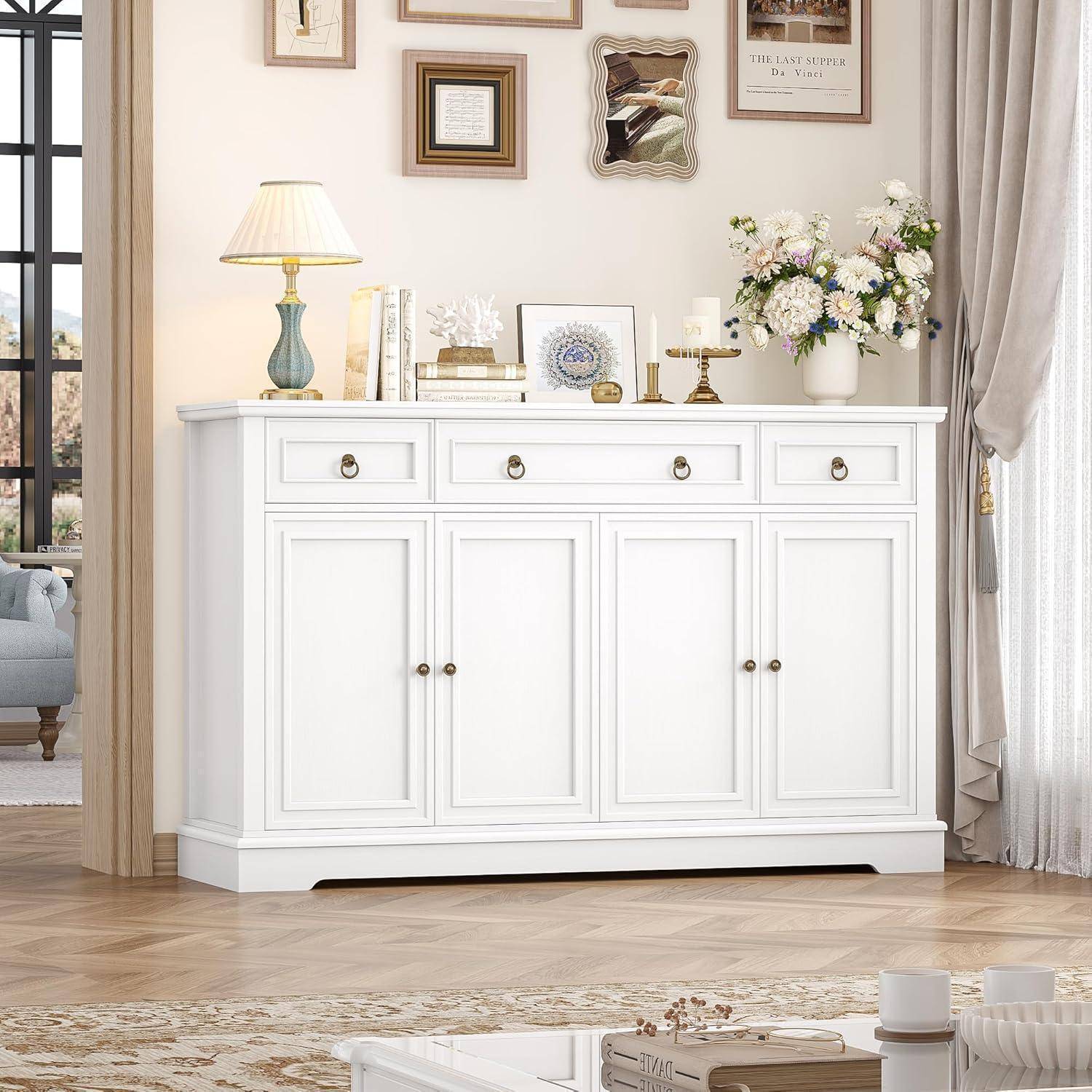 Weißer viertüriger Schrank mit Schubladen in einem hellen Wohnzimmer, verziert mit einer Lampe, Büchern, Dekoration und einer Blumenvase.