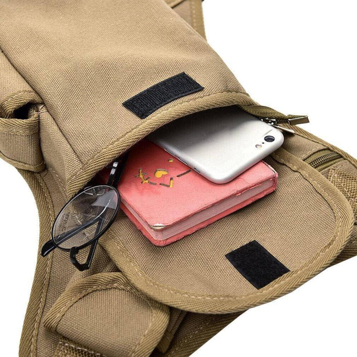 Offene hellbraune Tasche mit Tasche, in der sich ein Smartphone, ein kleines rosa Notizbuch und eine Brille befinden.