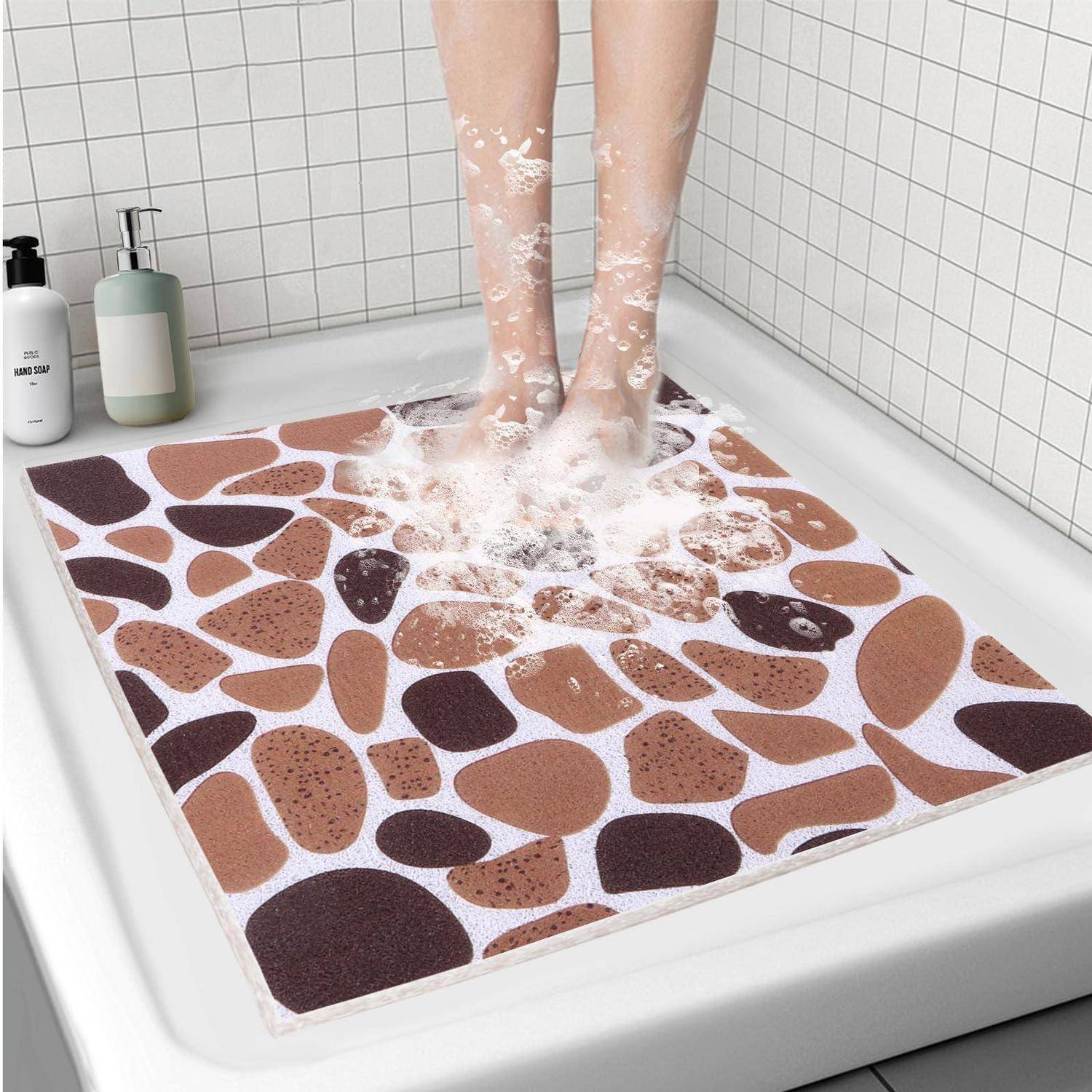Person steht auf einer Badmatte in einer Dusche, mit Wasser, das um ihre Füße spritzt; Seifenspender sitzen auf dem Wannenrand.